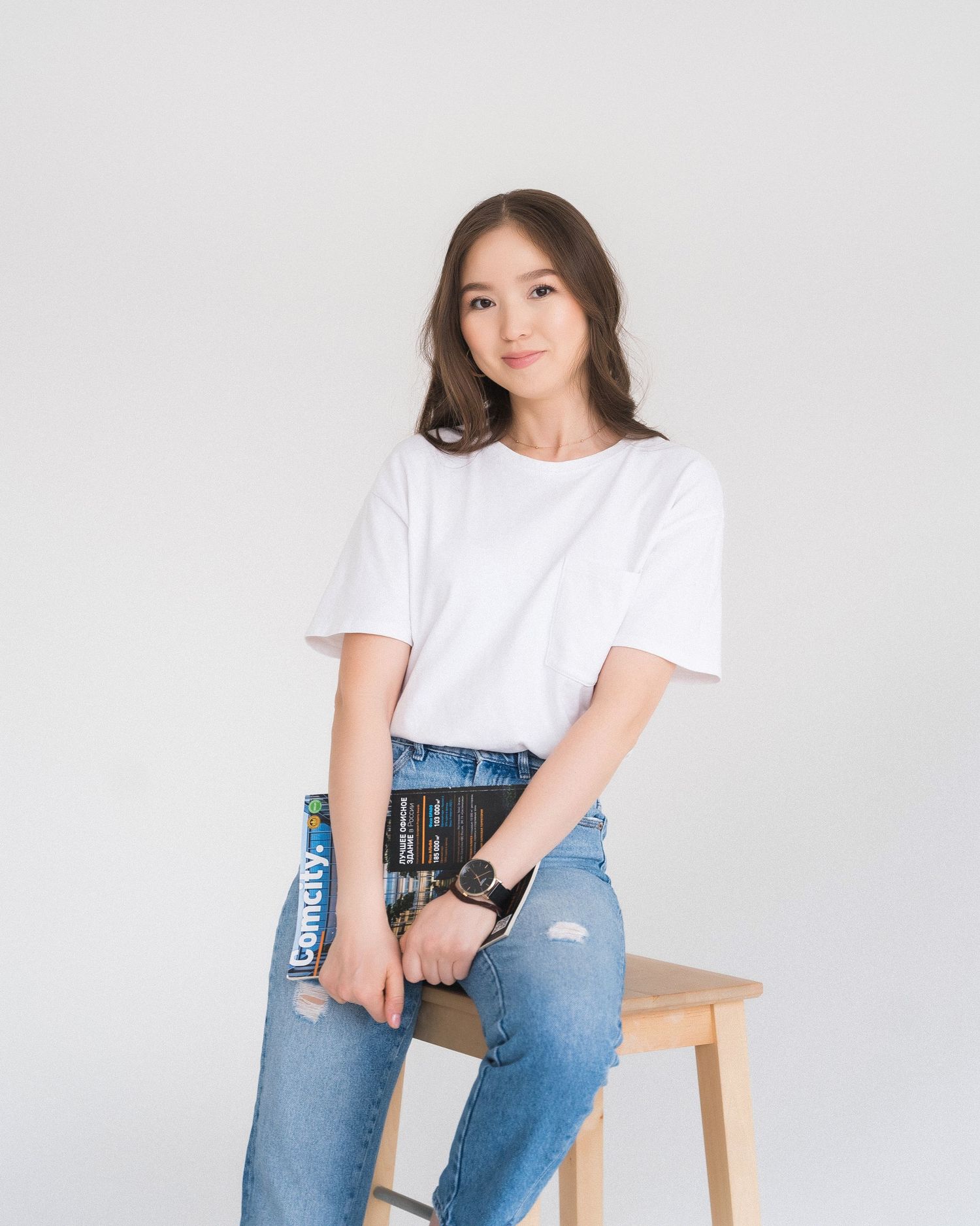 Casual lifestyle portraits on wooden stool in white t-shirt and jeans.