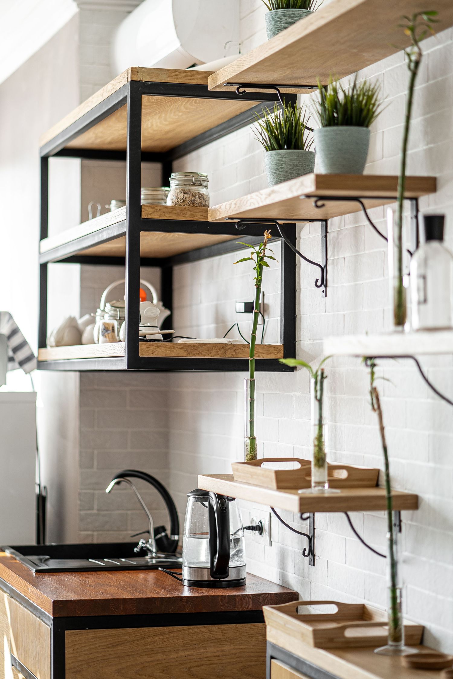 Row of minimalist bathroom vanities with wooden countertops and white tile backsplash.