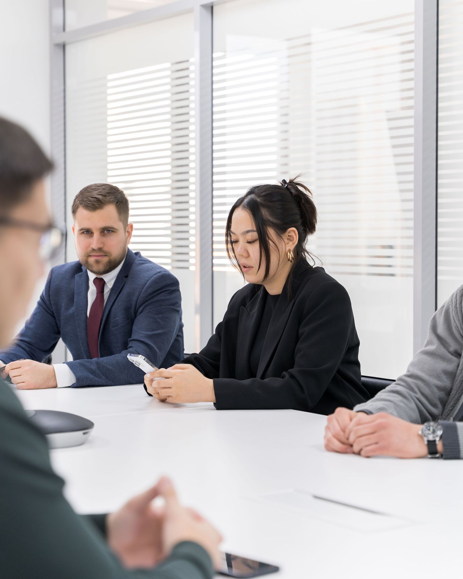 Business meeting in progress at modern conference room with white interior.