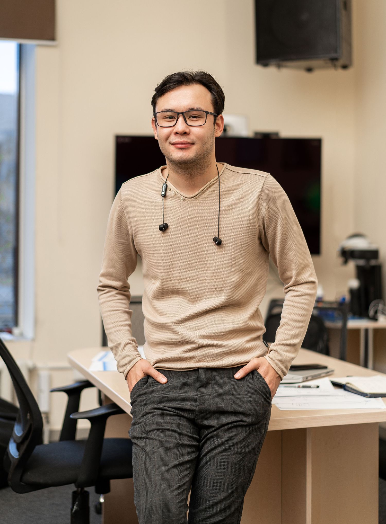 Person in casual attire sitting at desk in modern office space.
