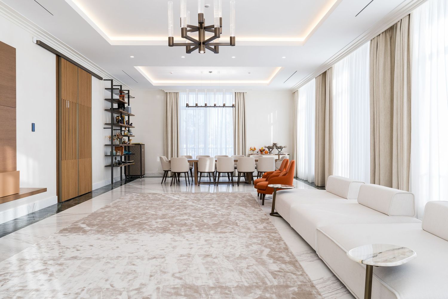 Spacious white living room with tray ceiling and large windows letting in natural light.