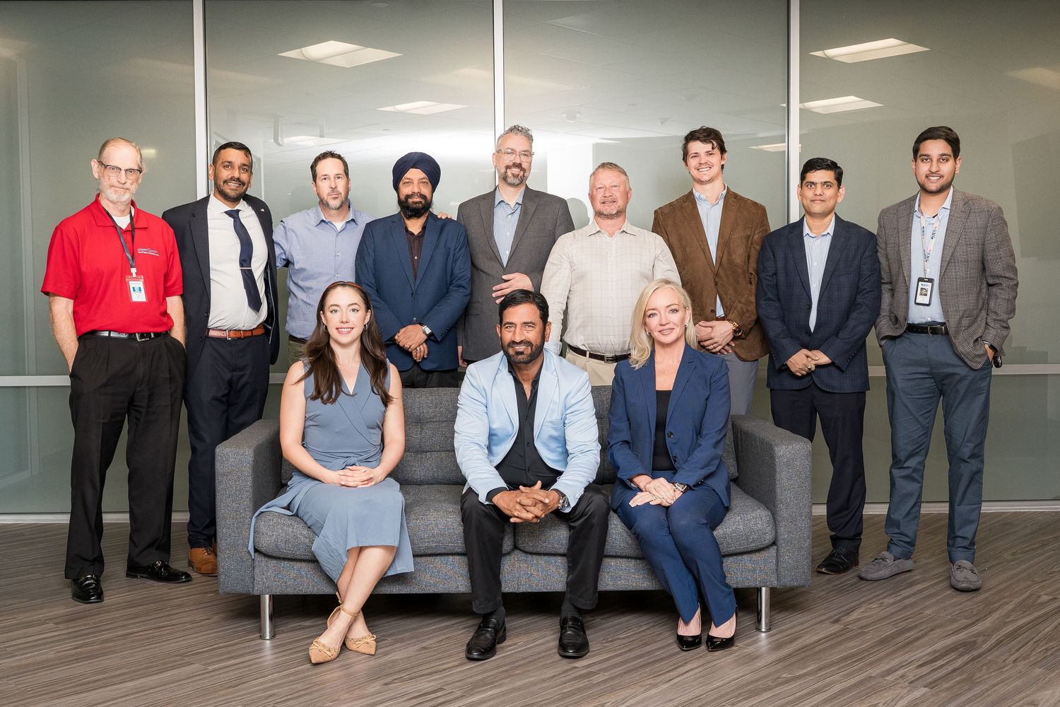 Large corporate team posing together in modern office space.
