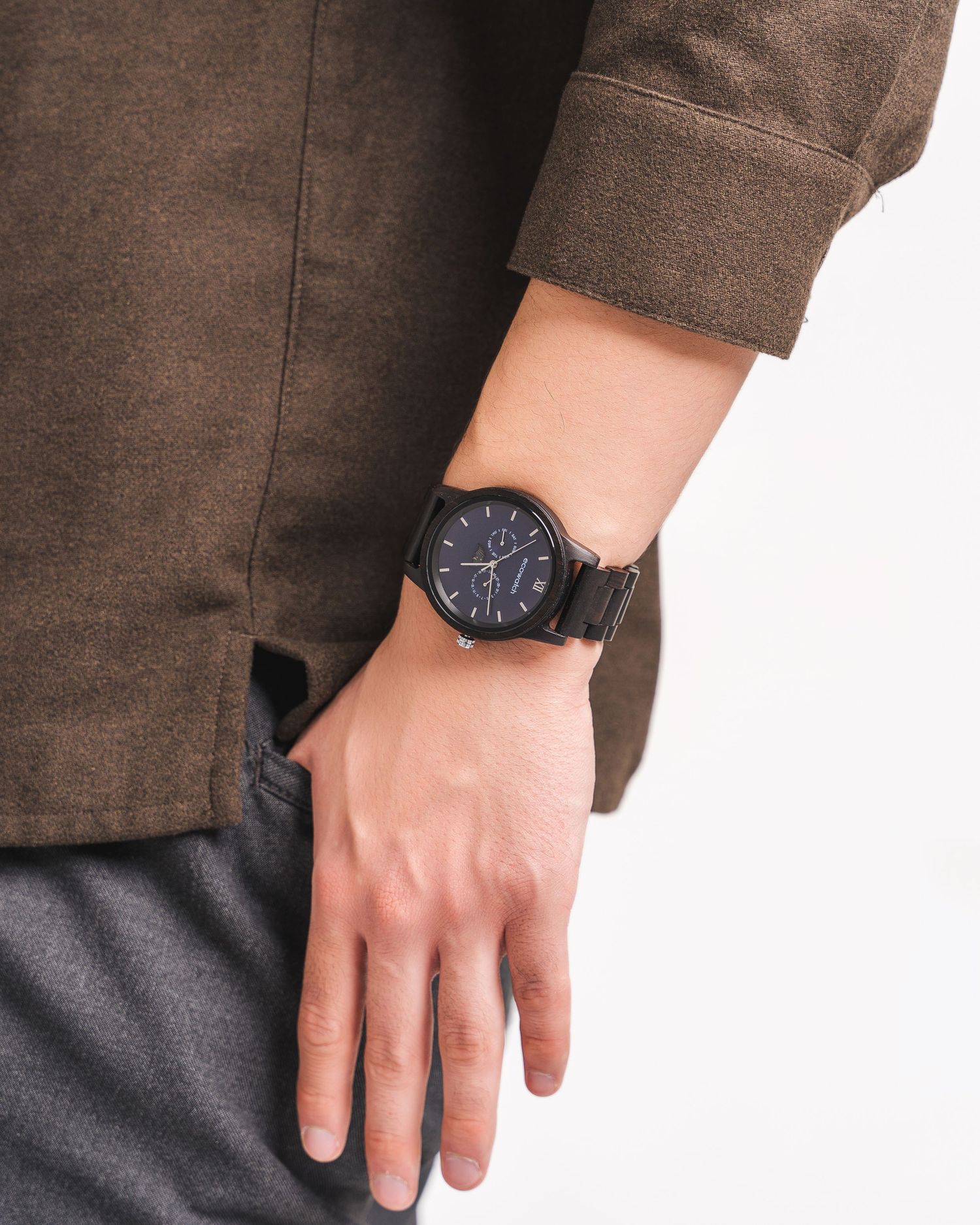 Detail shots of wrist watch worn with brown textured clothing.