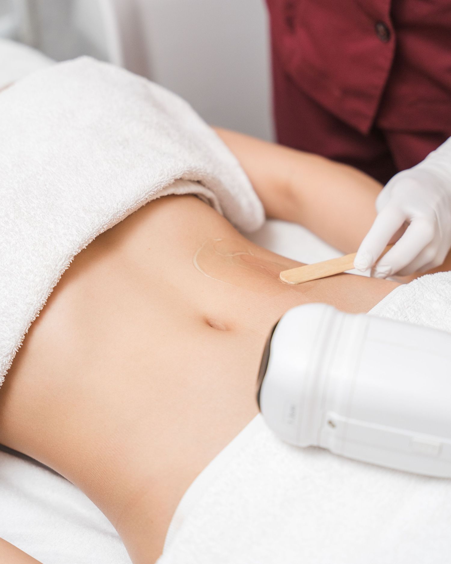 Professional spa treatment being administered with white towel and equipment.