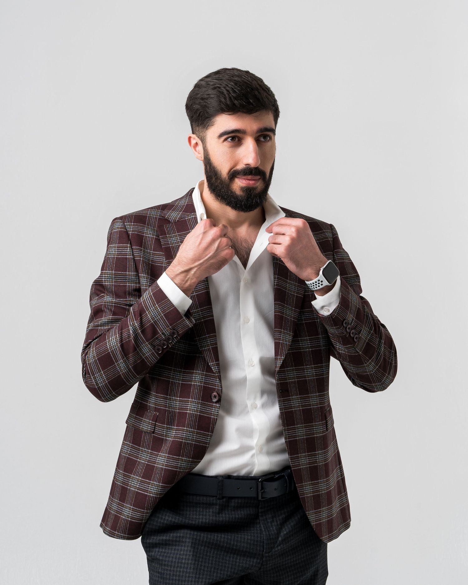 Person in plaid jacket and white shirt making expressive poses against white background.