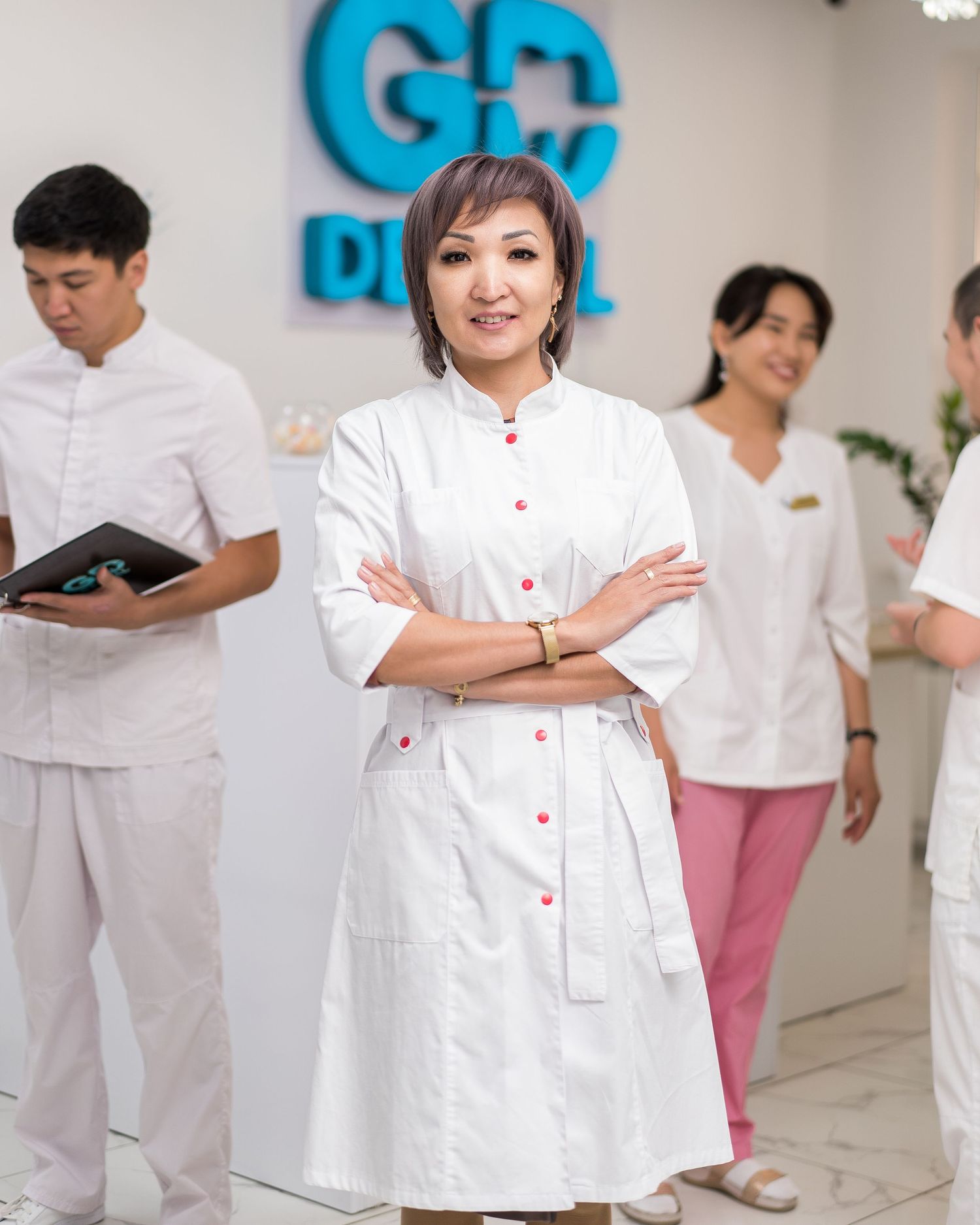 Medical staff gather in a bright clinic space with blue walls and white uniforms.