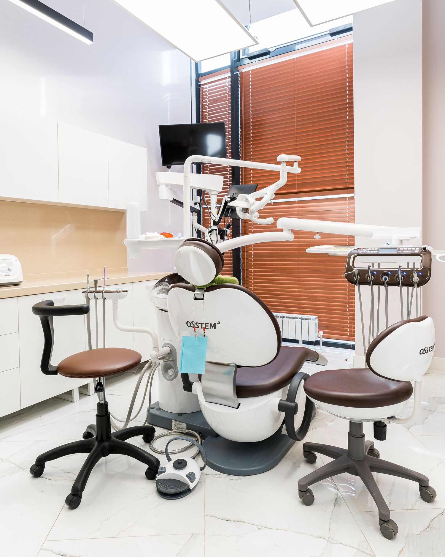 Modern dental clinic interior with multiple treatment chairs and equipment.