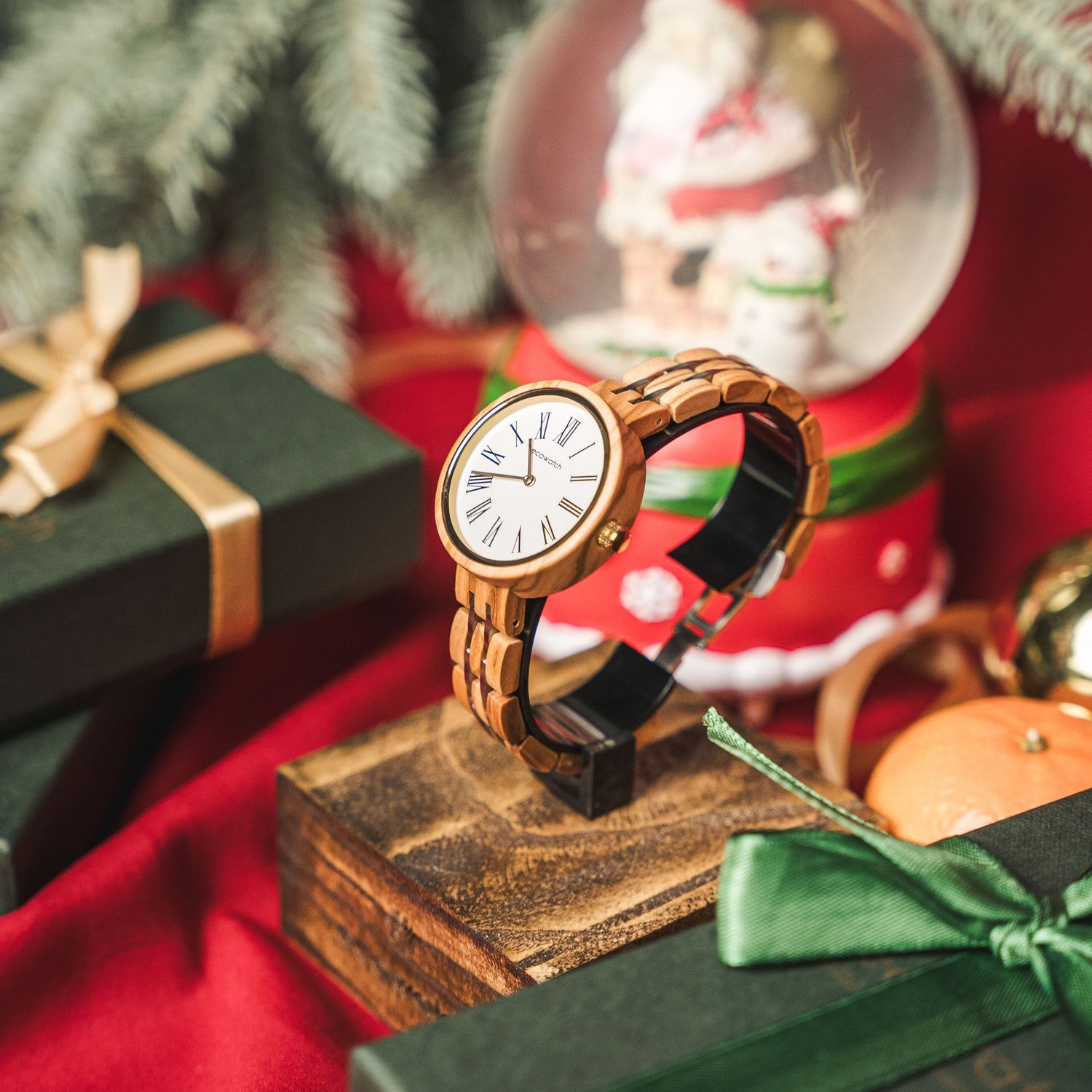 Vintage-style analog clock face with gold hands and leather strap against a festive red and green background.