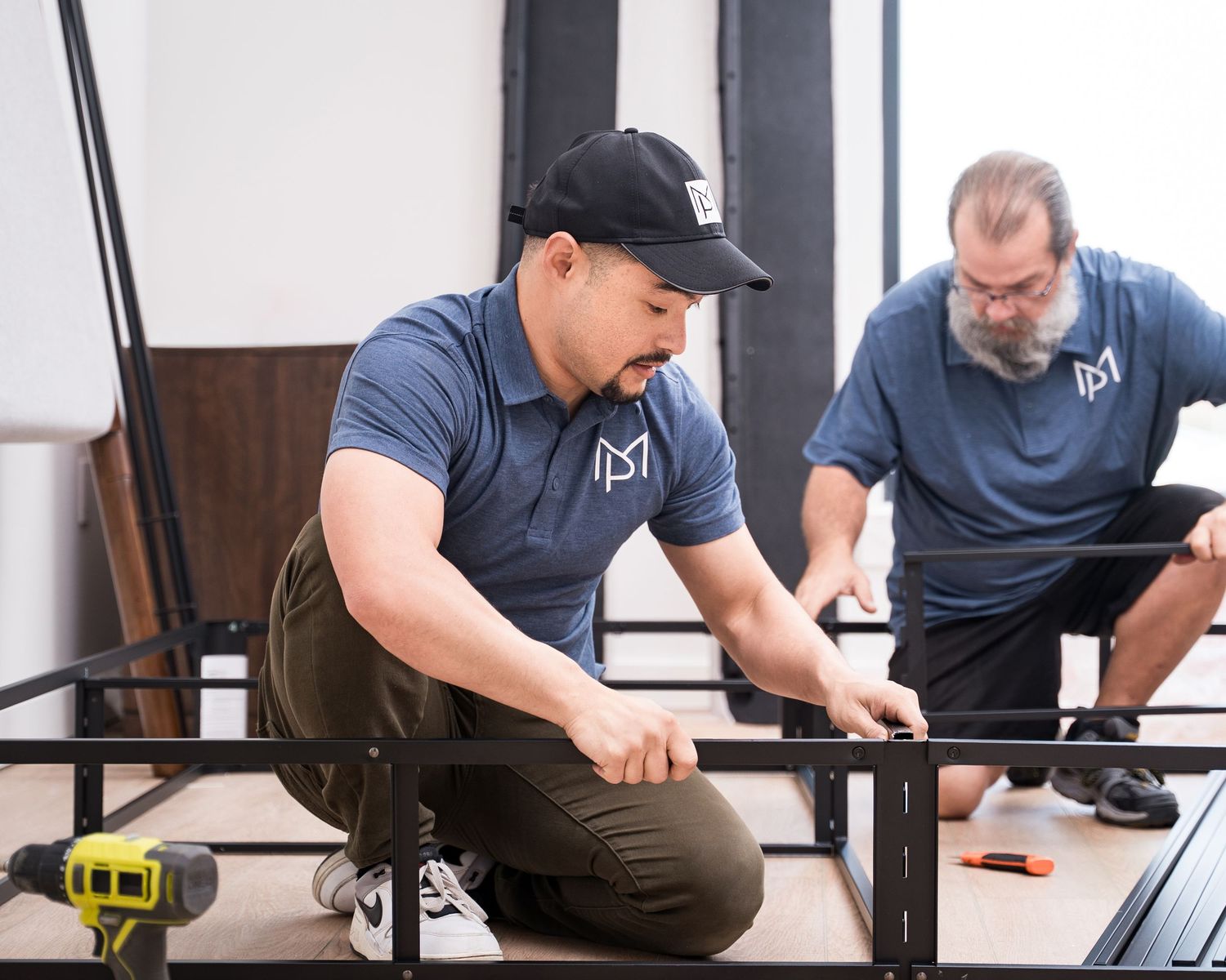 Team of workers in matching blue uniforms assembling furniture pieces.