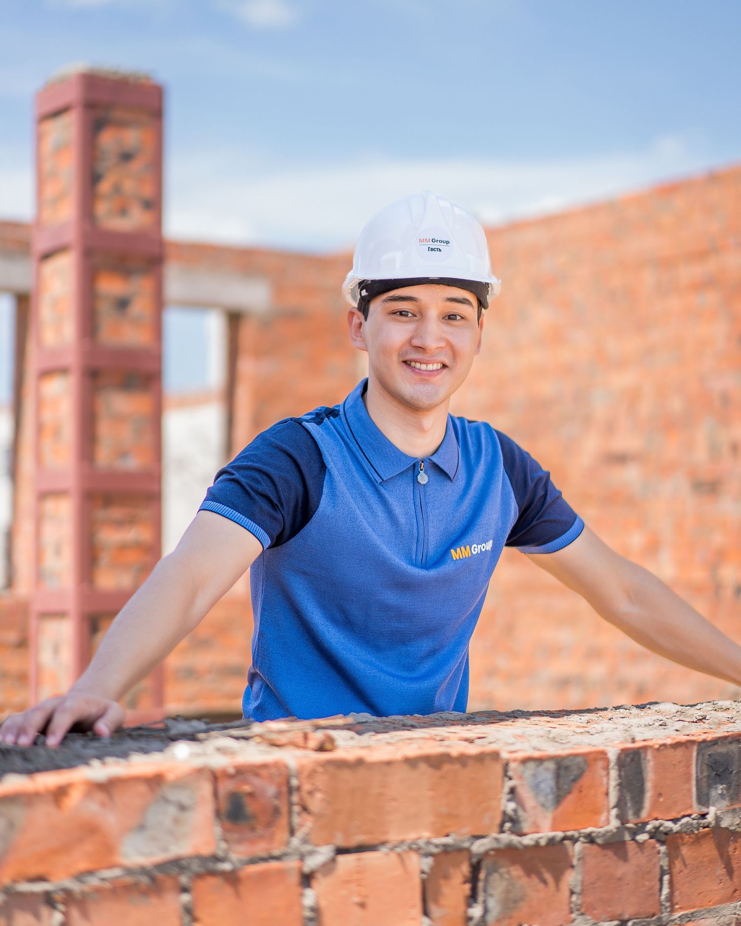 Bricklaying work in progress at a construction site with red bricks and mortar.