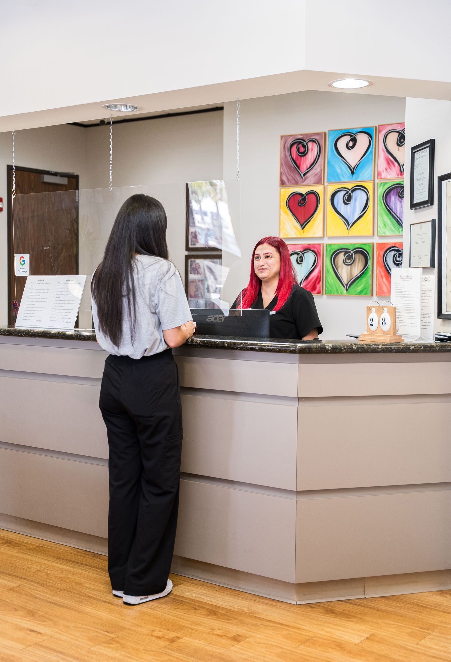 Medical office reception area with colorful heart artwork on wall.