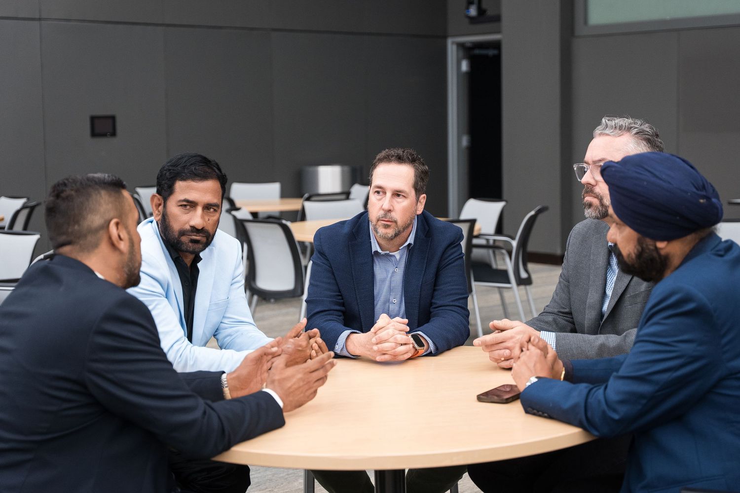 Team of professionals engaged in discussion at modern office meeting table.