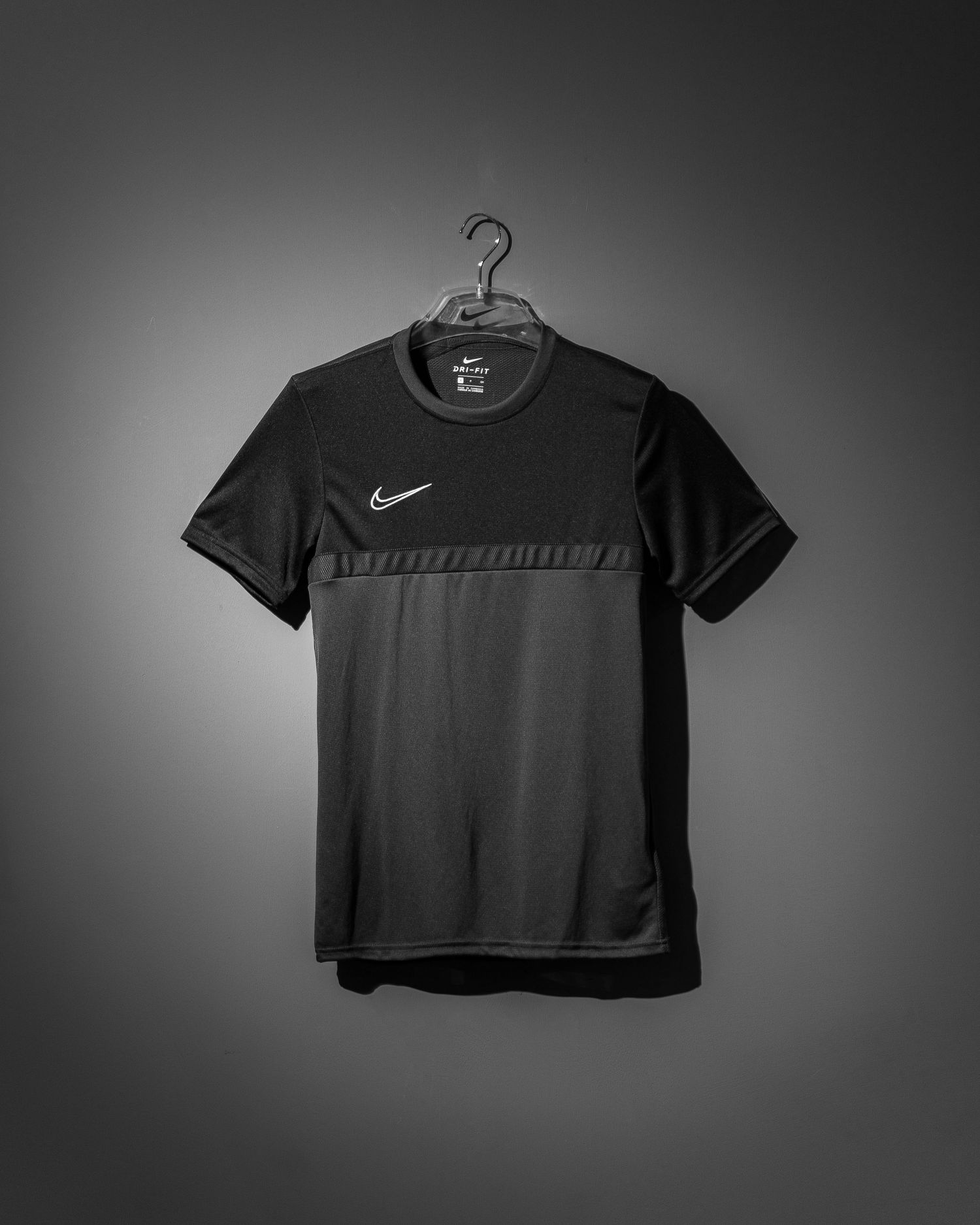 Black Nike crop top t-shirts displayed in a minimalist style against dark background.
