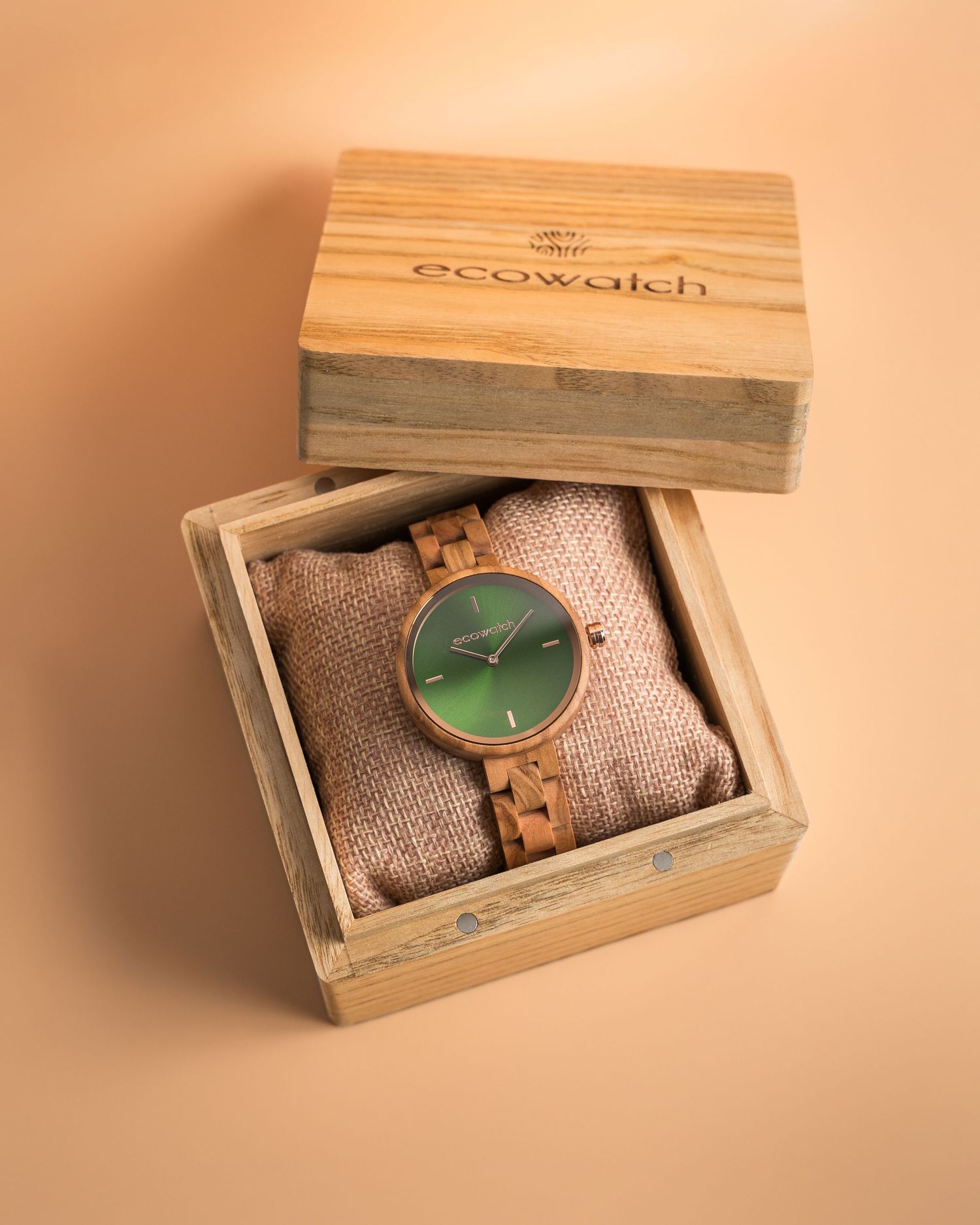 Wooden eco-watch with green face displayed in branded bamboo box.