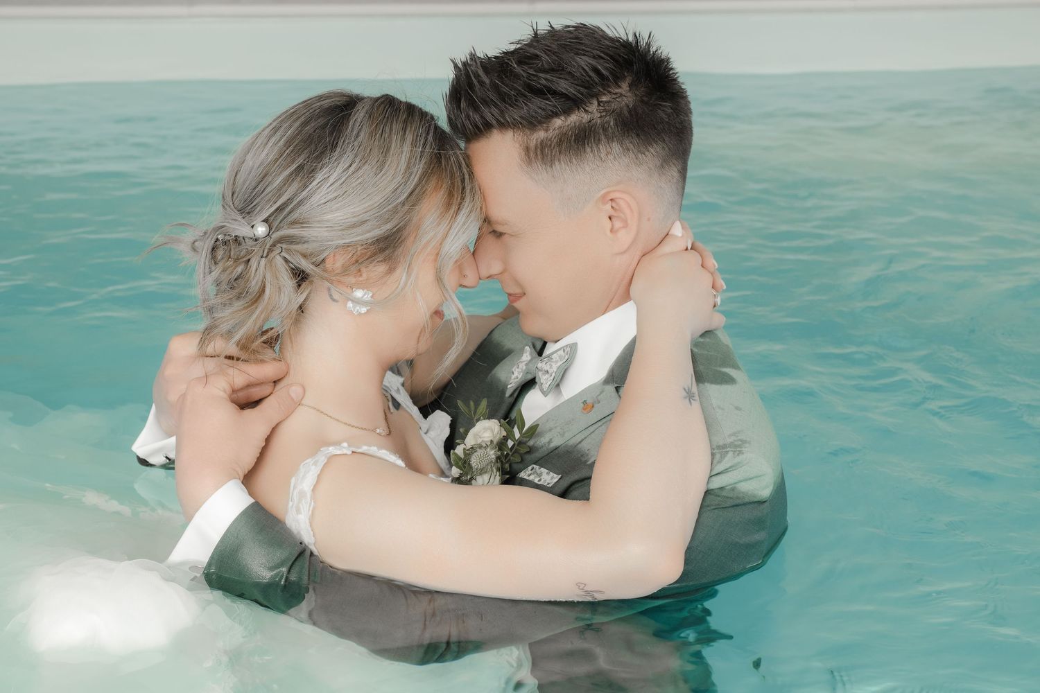 Couple de mariés s'enlaçant dans une piscine, photo de mariage