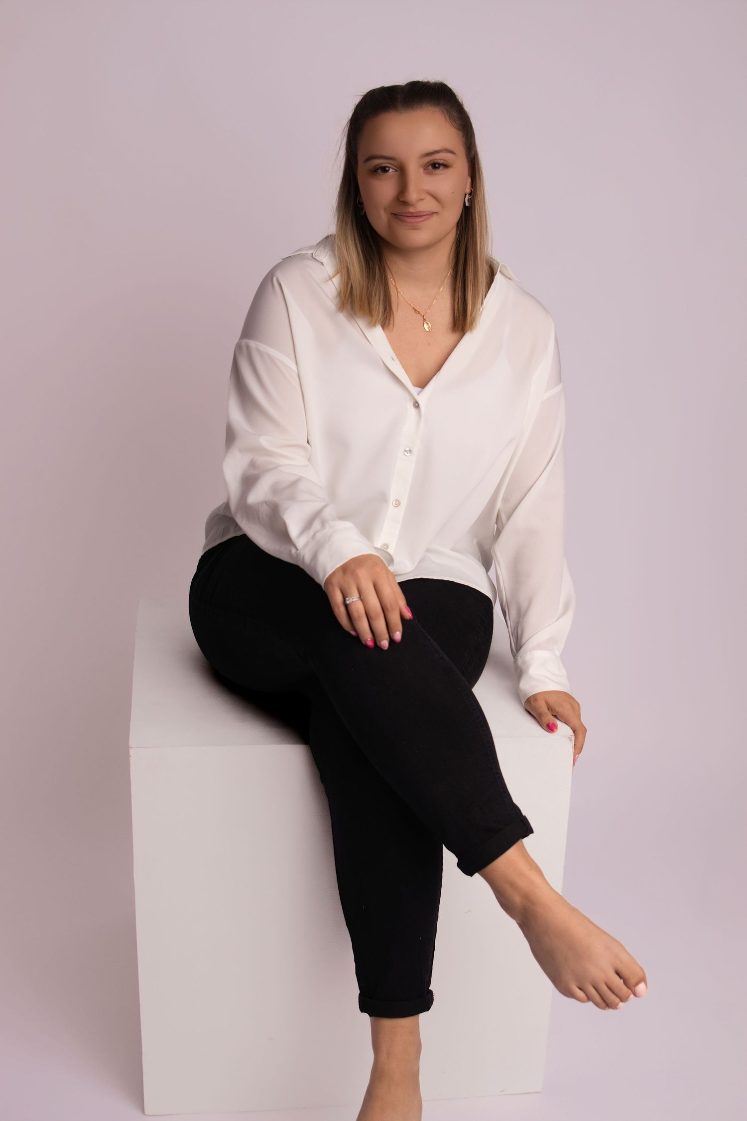 Portrait studio d'une femme en chemise blanche assise sur un cube, par Cindy Poulet Photographe à Septvaux.