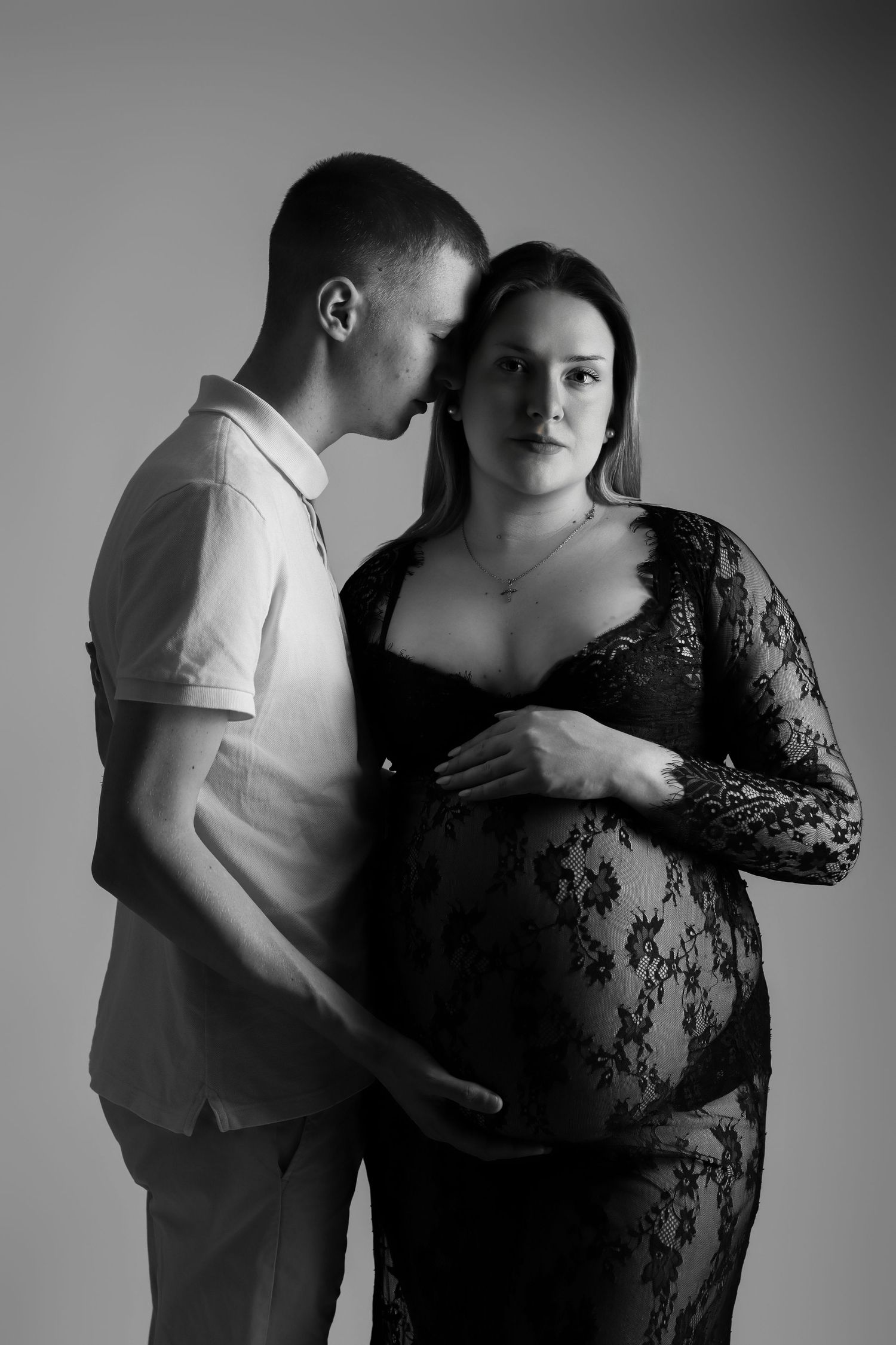 Portrait artistique en noir et blanc d'un couple lors d'une séance photo de grossesse en studio, par Cindy Poulet Photographe