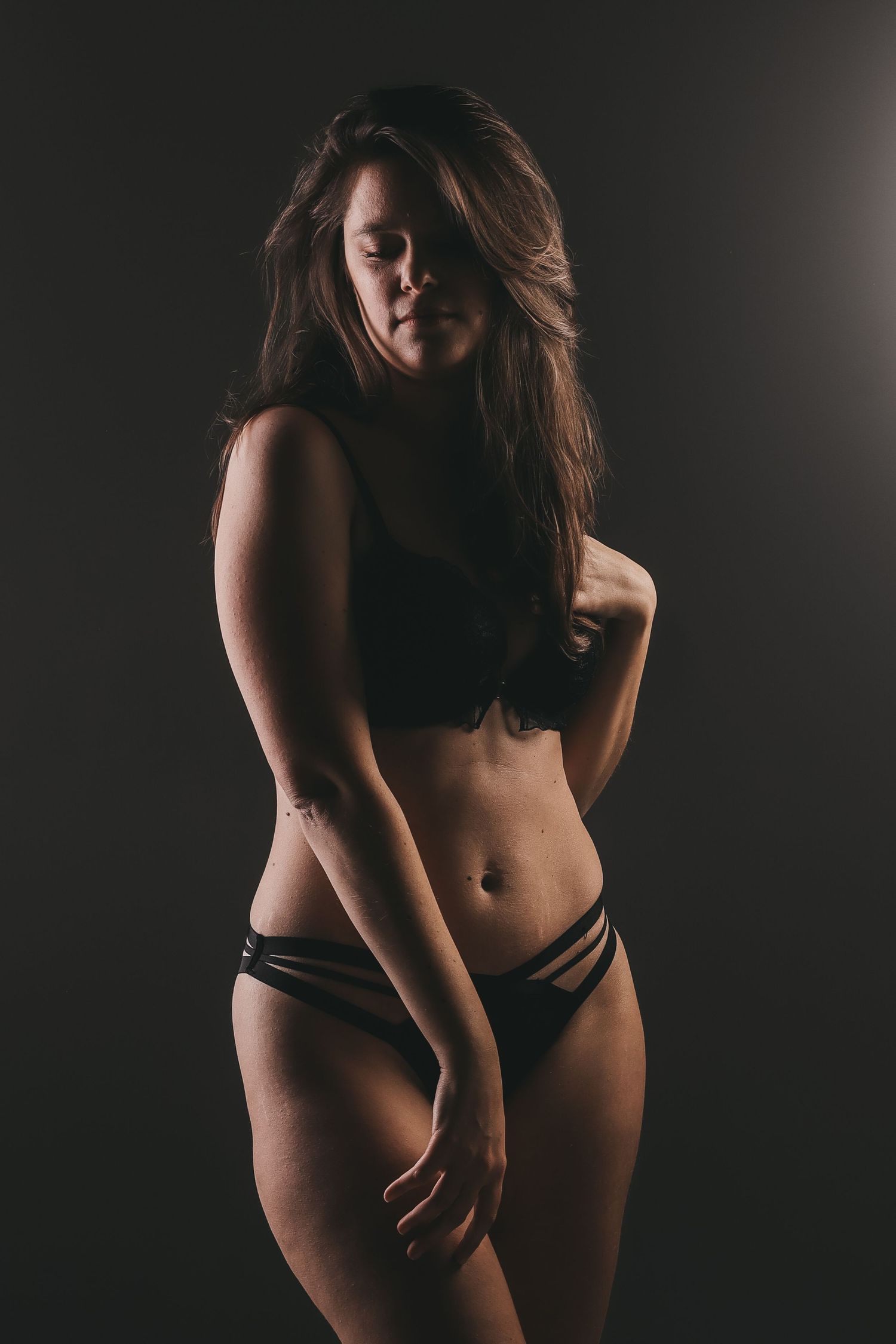 Femme en sous-vêtements noirs se tenant debout, portrait boudoir sombre - Cindy Poulet photographe