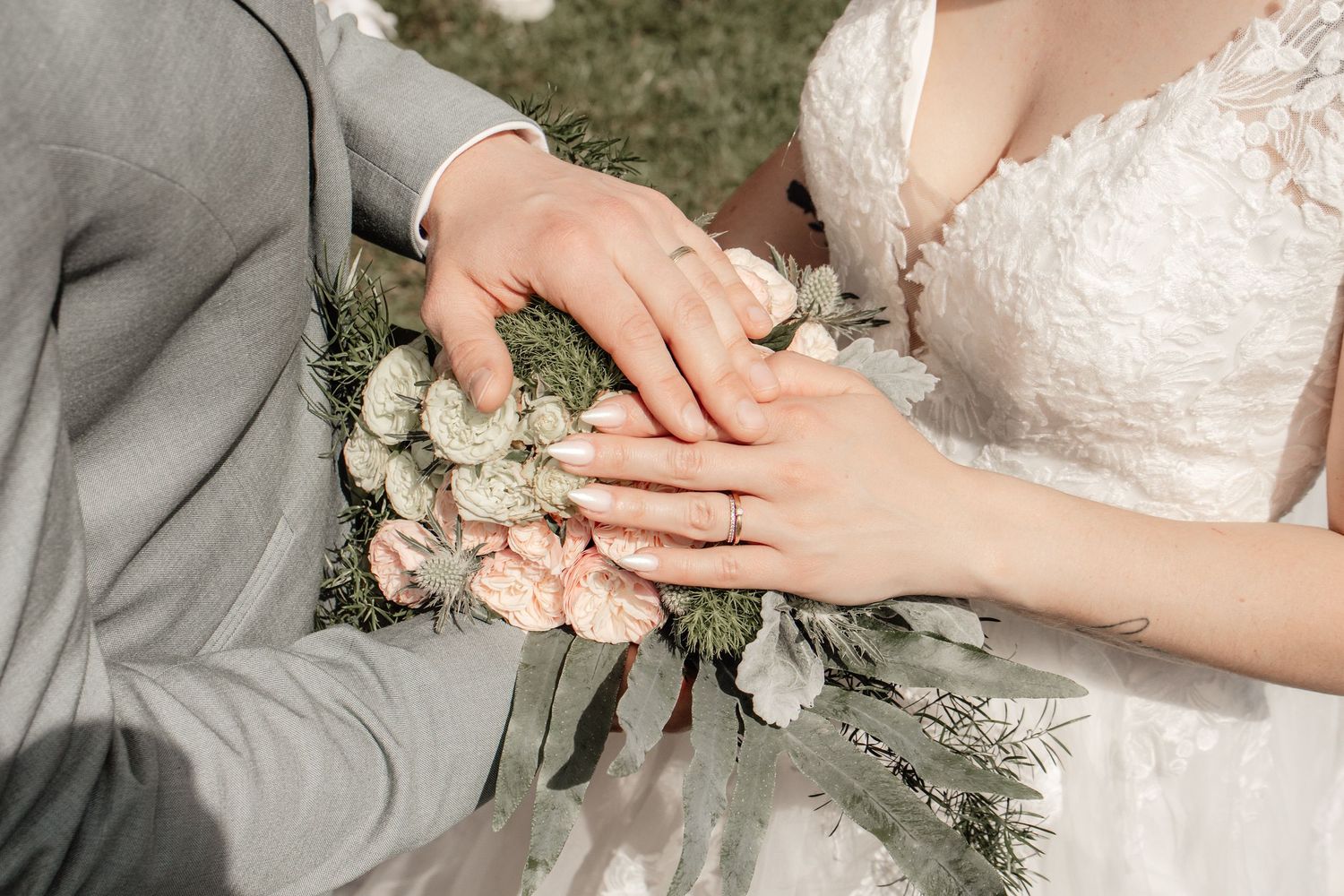 Mains des mariés tenant un bouquet de fleurs, alliance, photo mariage