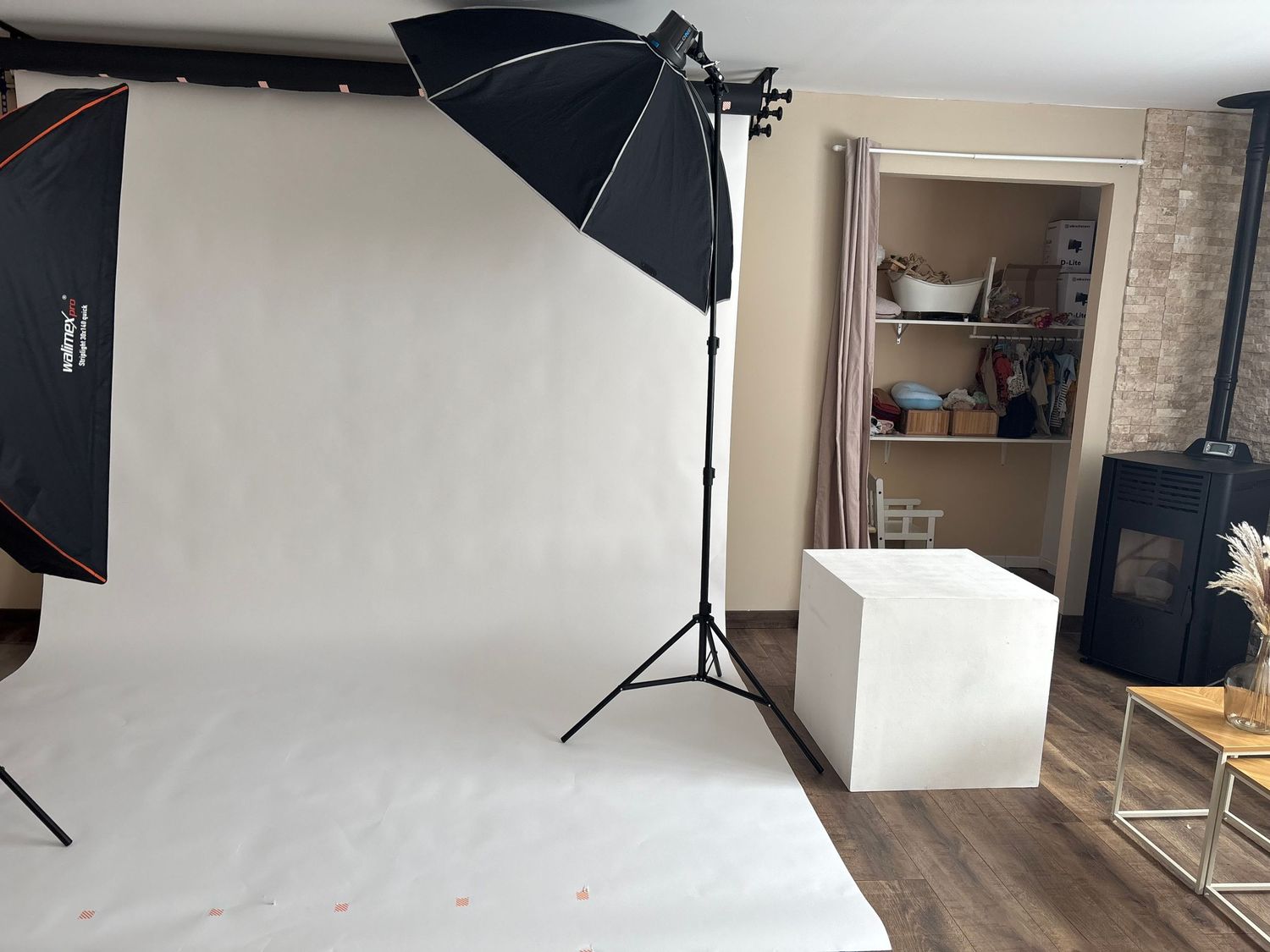 Studio de Cindy Poulet Photographe : coulisses avec fond blanc, éclairages softbox et cube de pose pour portraits et nouveau-nés.