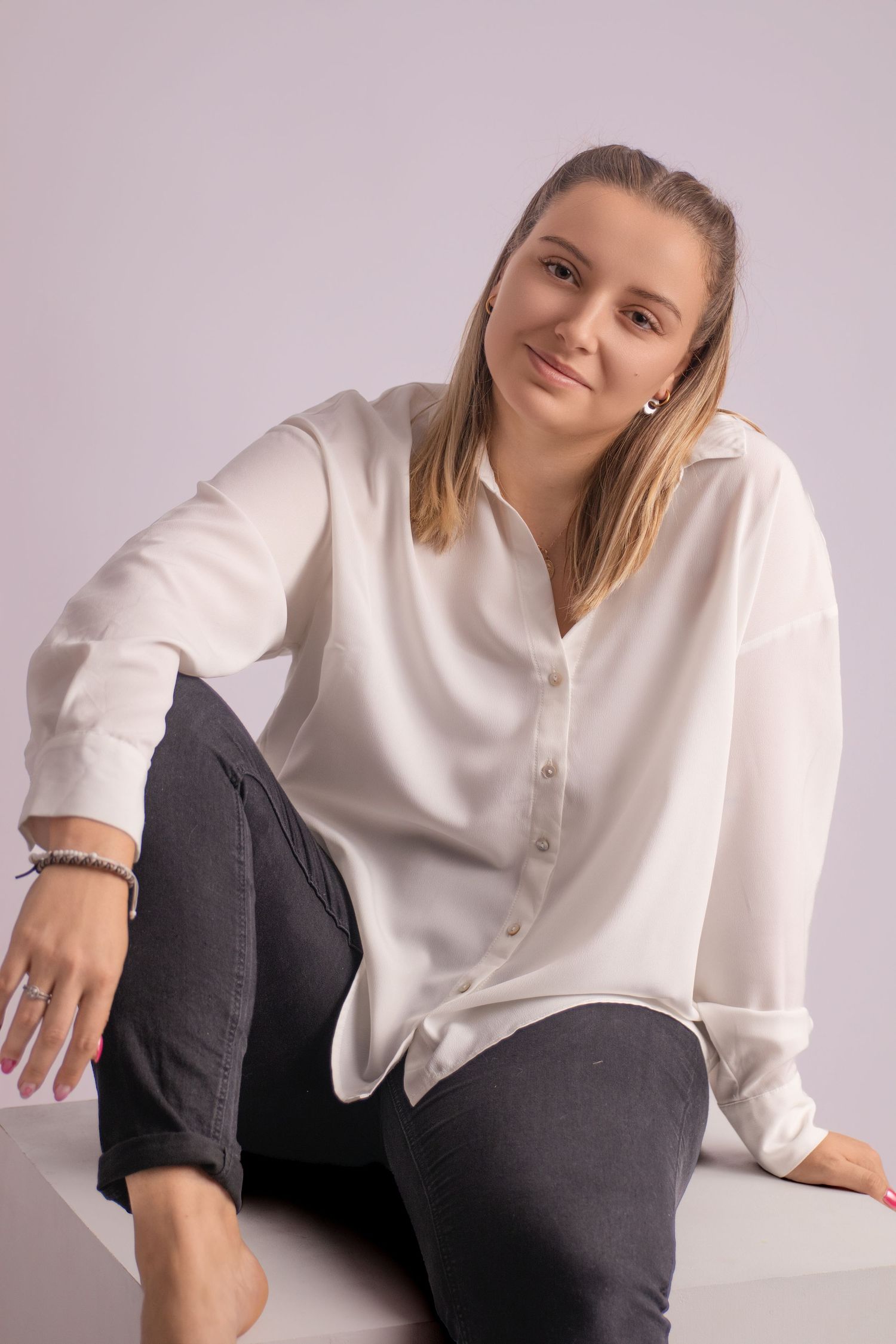 Portrait de studio d'une femme souriante en chemise blanche, par Cindy Poulet Photographe à Septvaux.