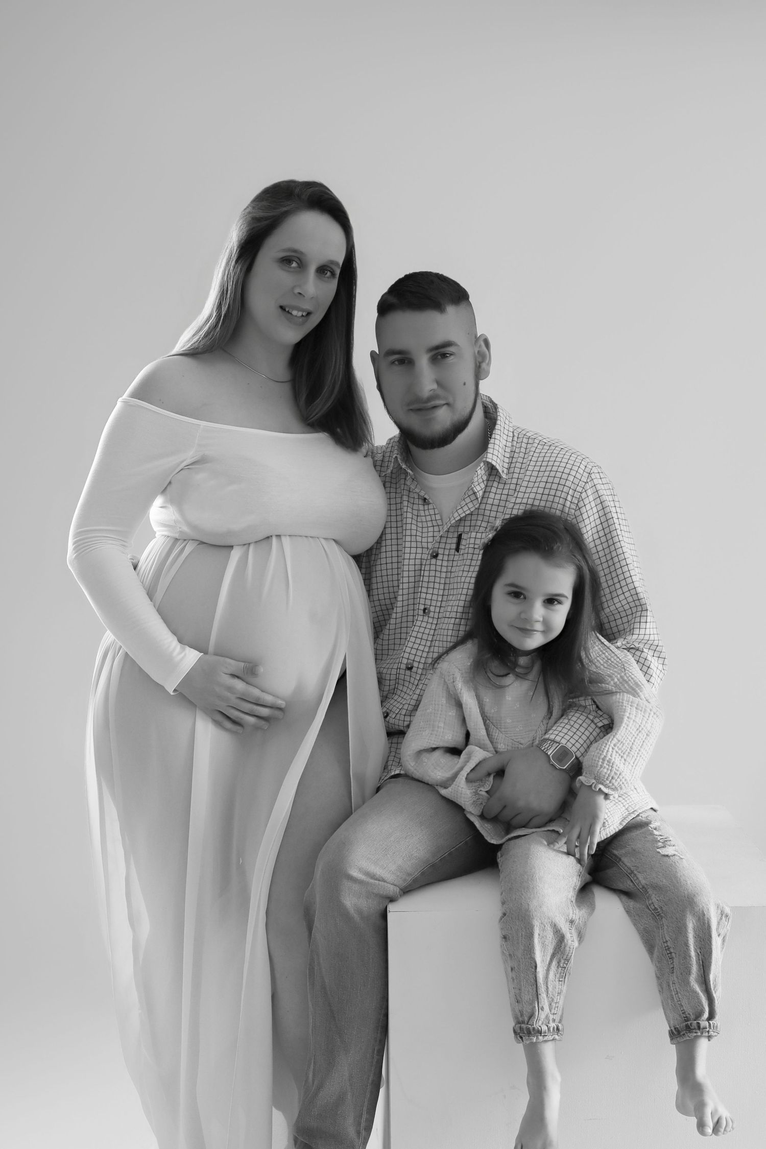 Portrait de famille en noir et blanc avec femme enceinte, séance photo maternité en studio par Cindy Poulet Photographe