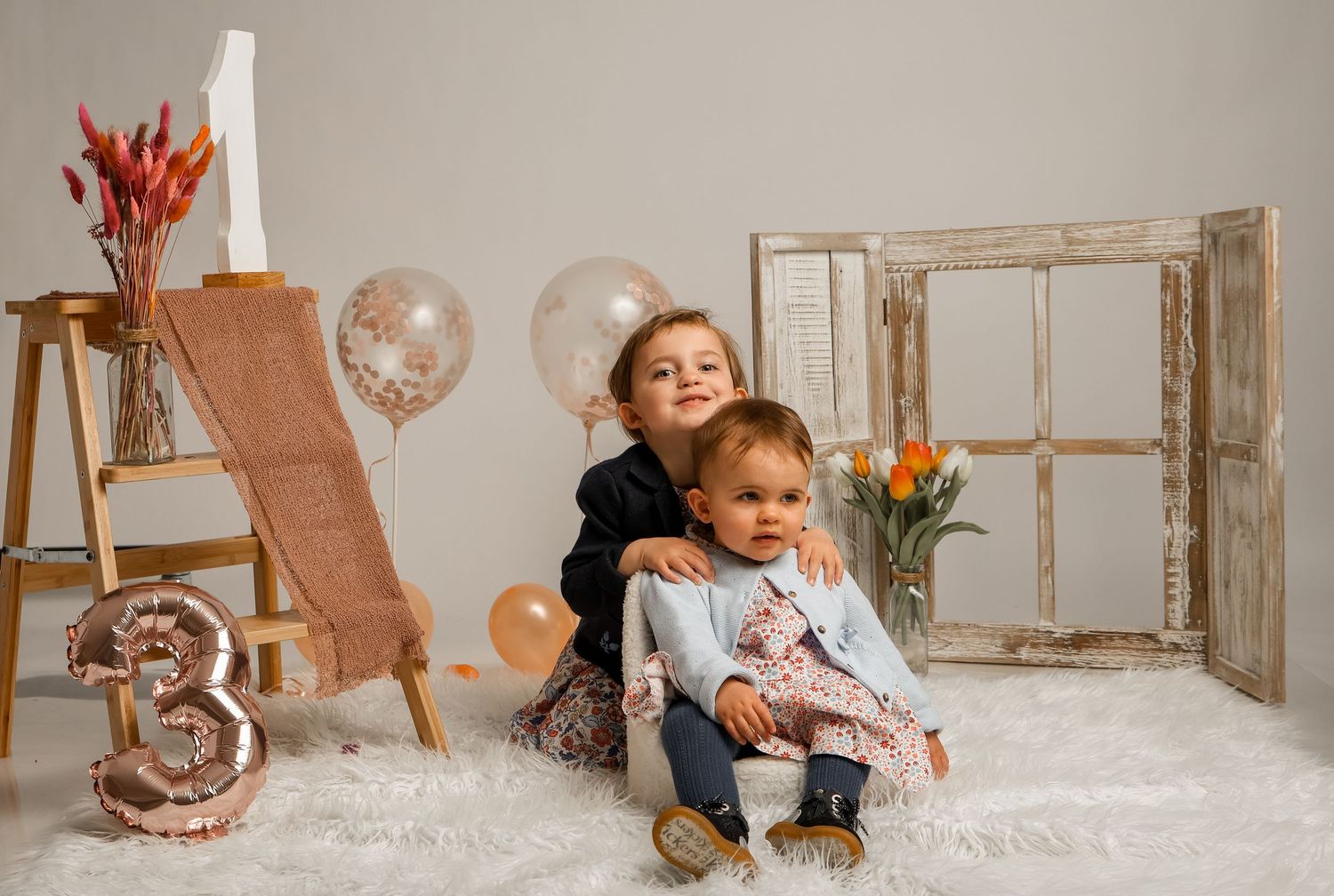 Deux enfants posant pour une séance photo anniversaire avec décoration