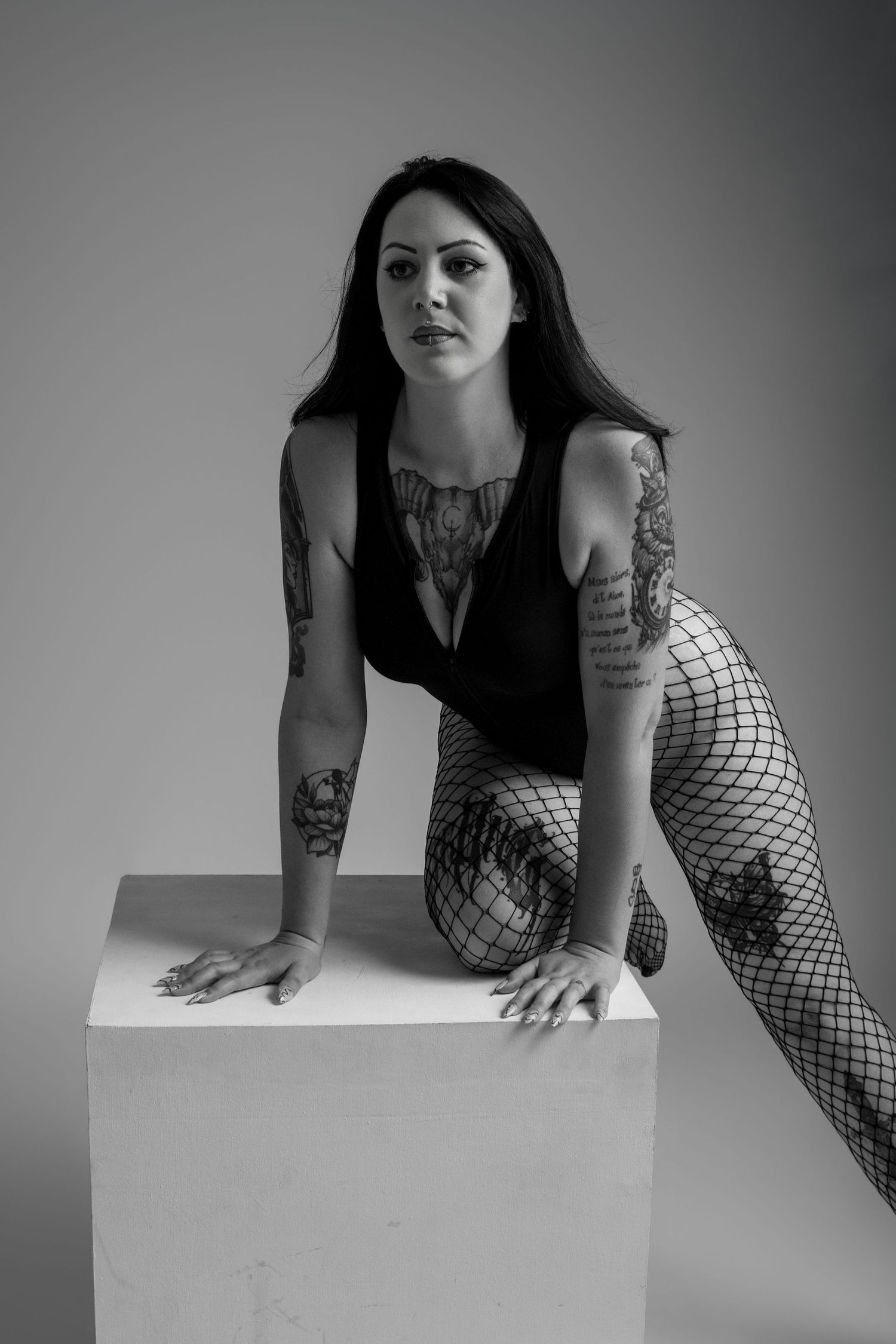 Femme en noir et blanc penchée vers un cube blanc, portrait boudoir - Cindy Poulet photographe