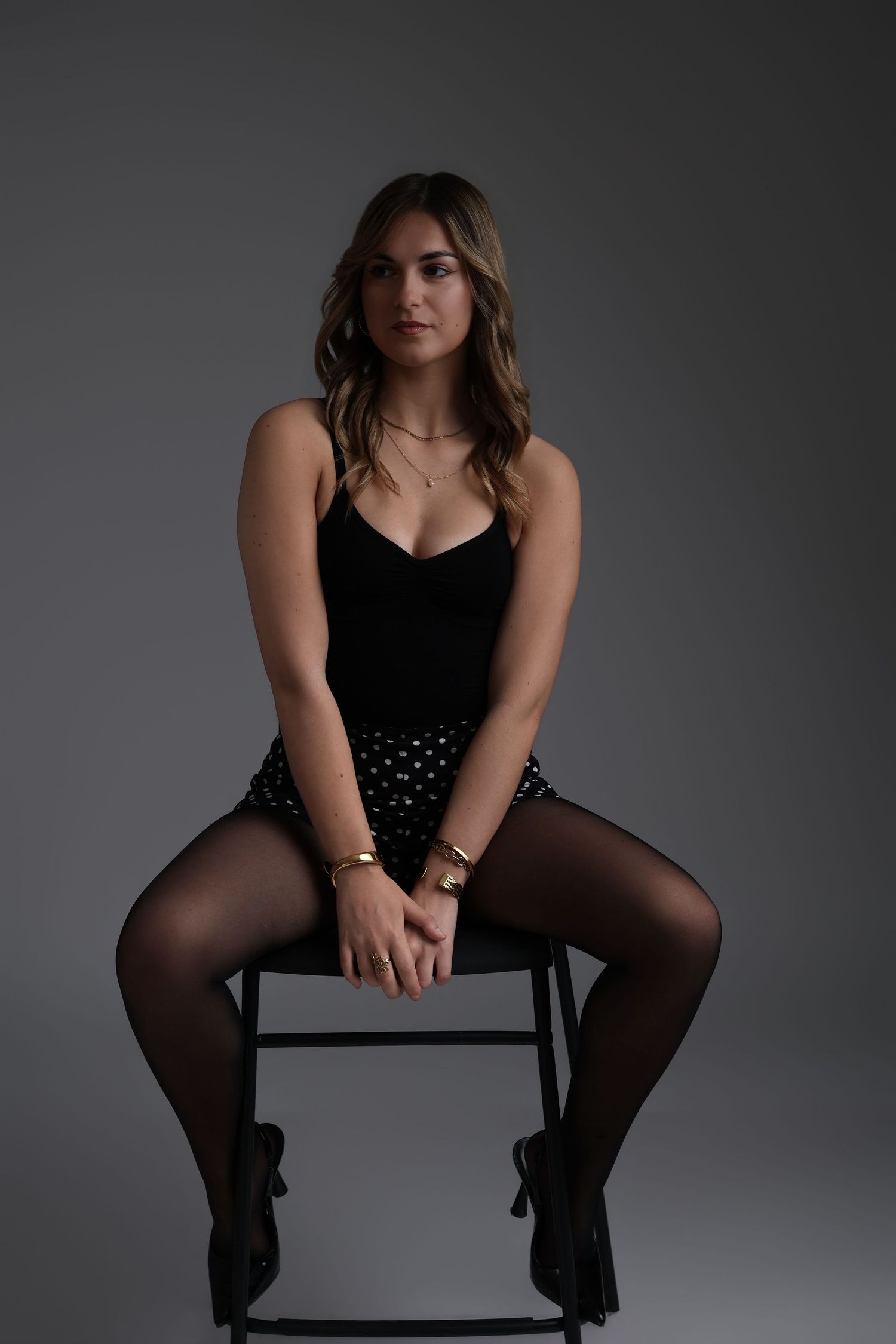 Femme en tenue noire assise sur un cube blanc, portrait studio - Cindy Poulet photographe