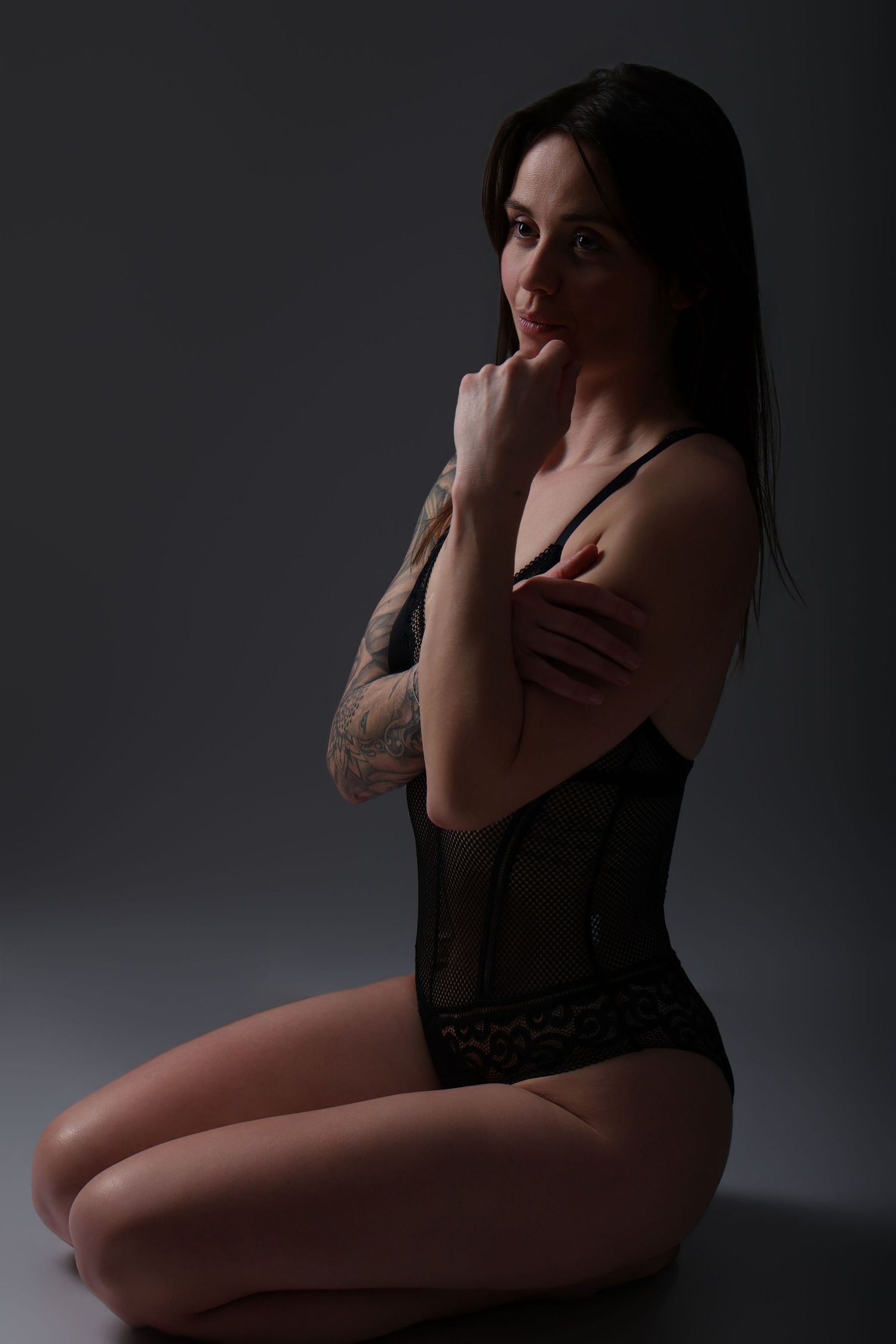 Femme enceinte de profil en tenue noire, silhouette sur fond sombre