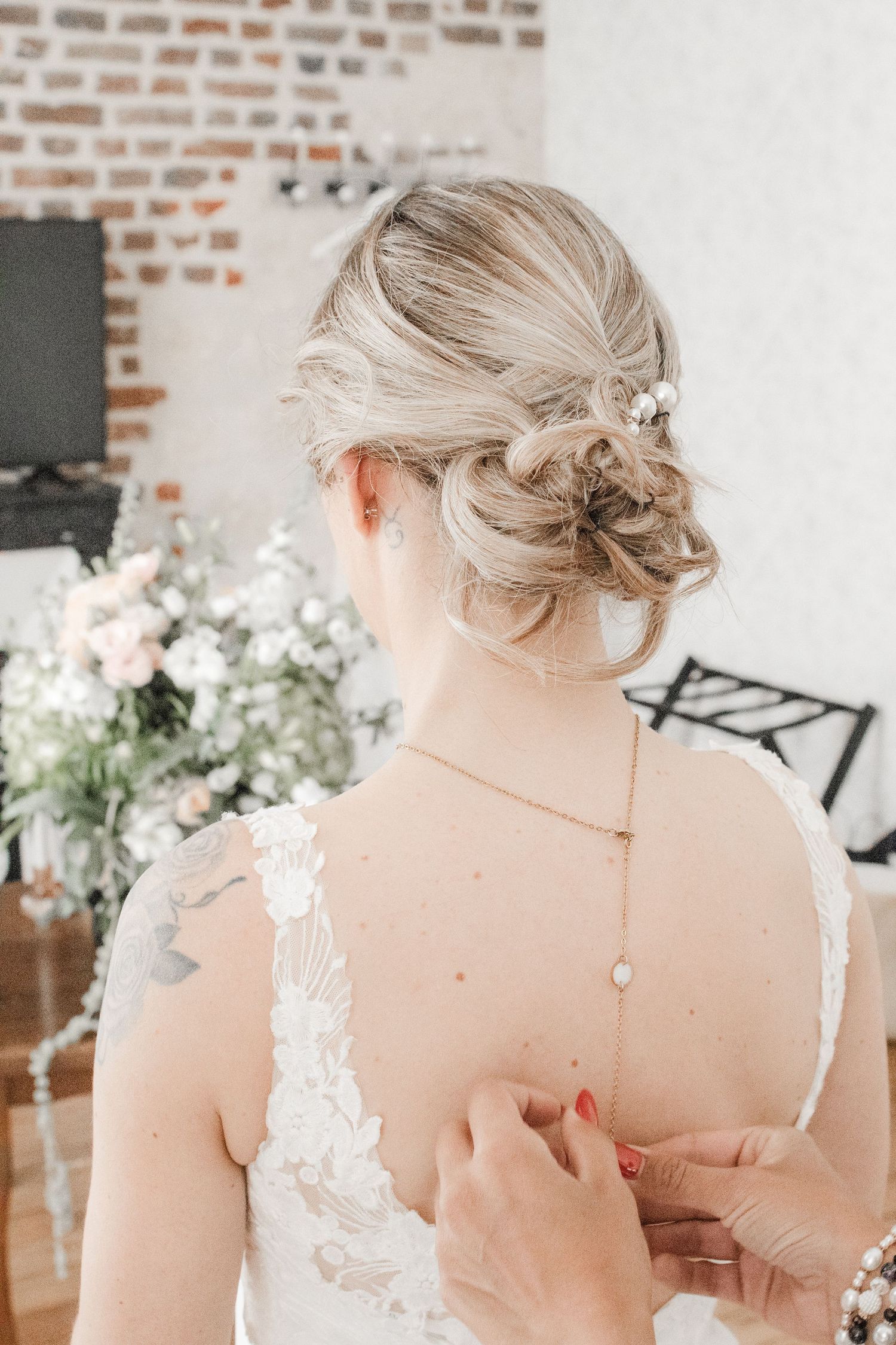 Mariée de dos coiffure élégante et robe dos nu, préparatifs mariage