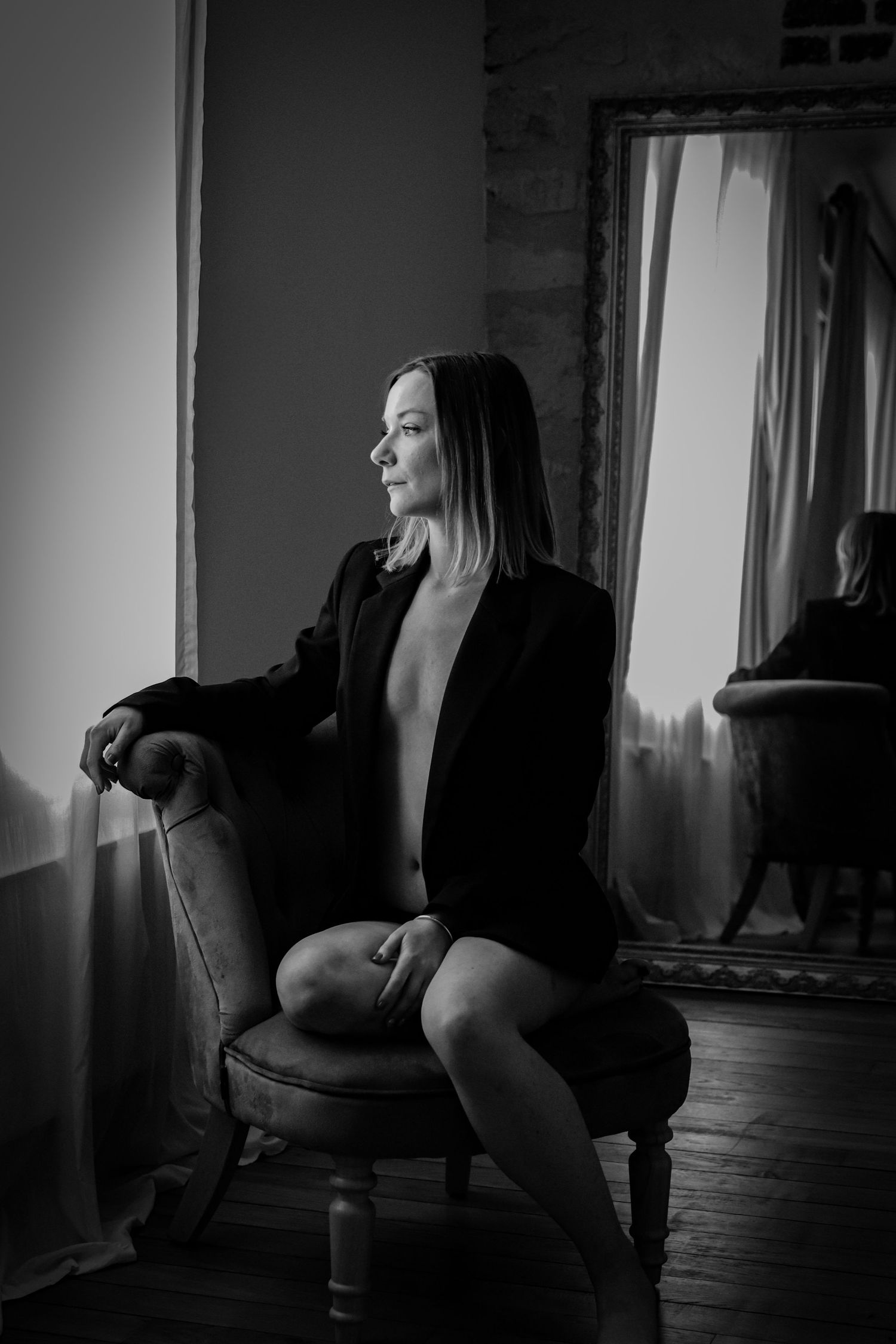 Femme assise dans un fauteuil, portrait boudoir en noir et blanc