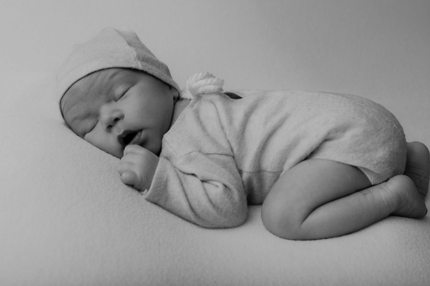 Nouveau-né endormi en body blanc avec bonnet, portrait naissance en noir et blanc - Cindy Poulet photographe