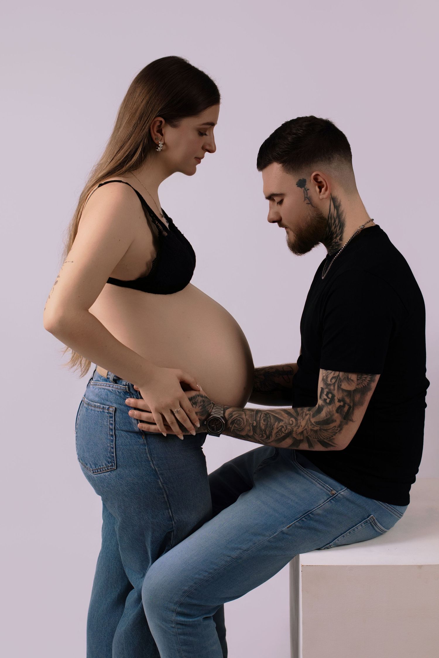 Photo de grossesse complice : futur papa regardant le ventre de la maman. Séance maternité par Cindy Poulet à Septvaux, près de Laon.