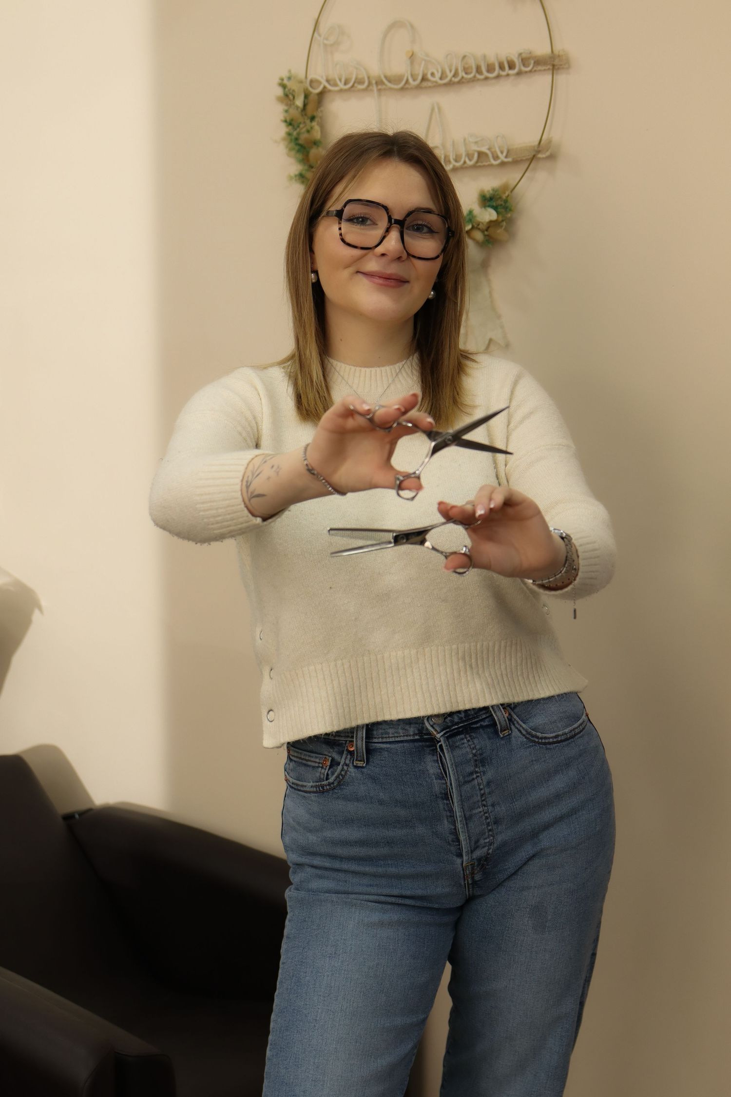 Portrait d'une coiffeuse souriante tenant ses ciseaux, par Cindy Poulet Photographe proche Laon.