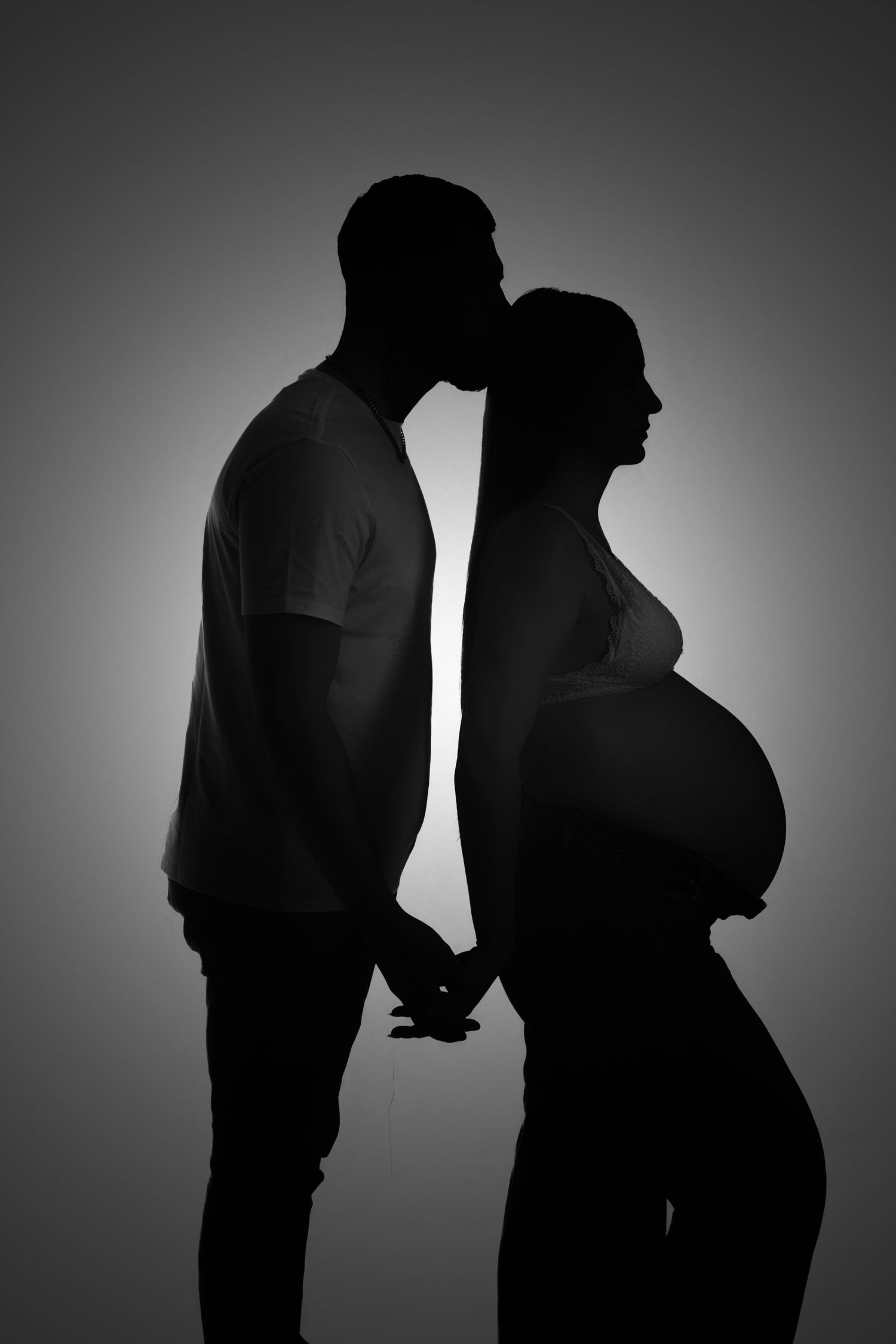 Silhouette de couple attendant un bébé, photographie grossesse artistique en noir et blanc