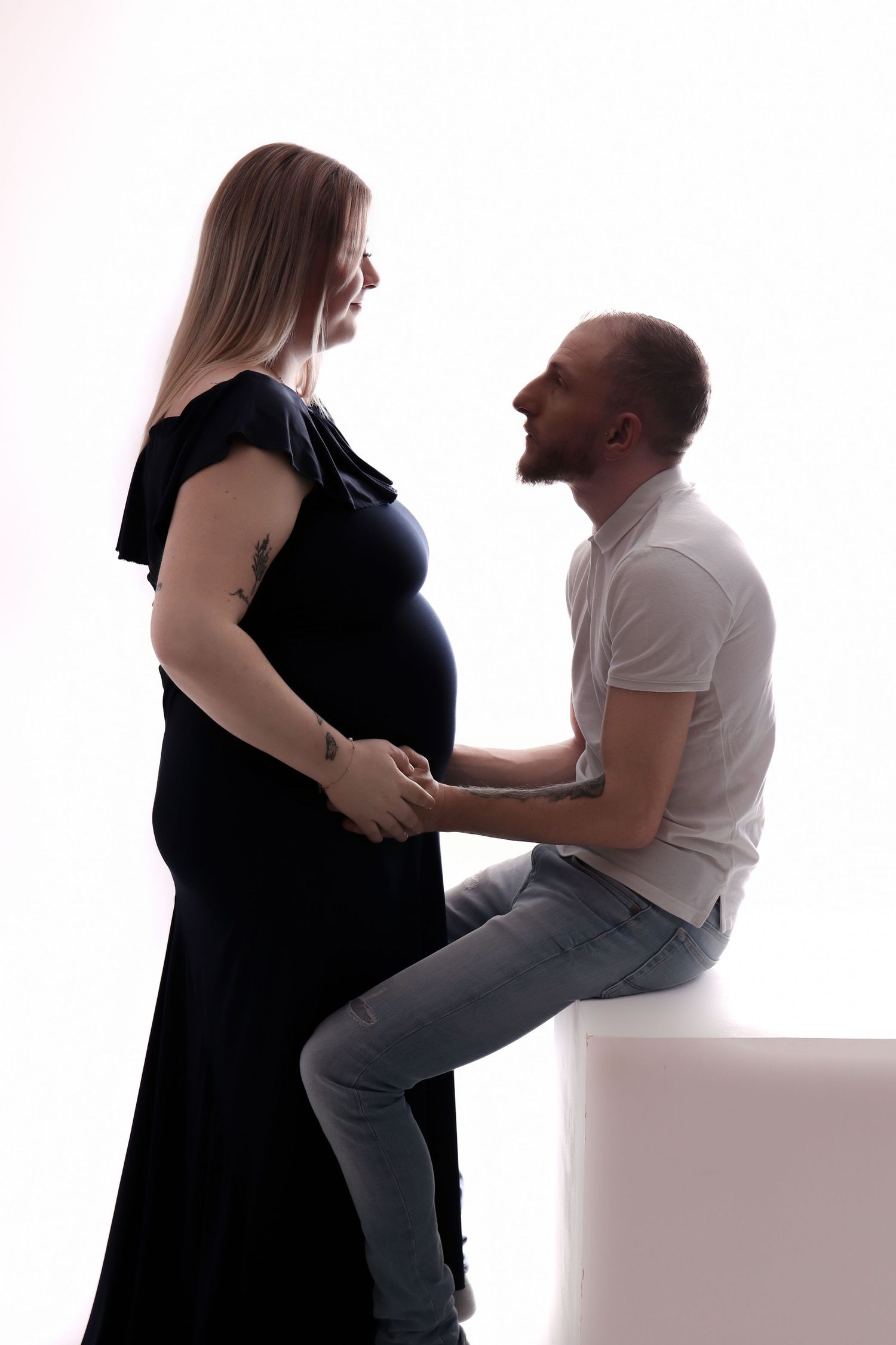 Couple avec femme enceinte se regardant tendrement en studio