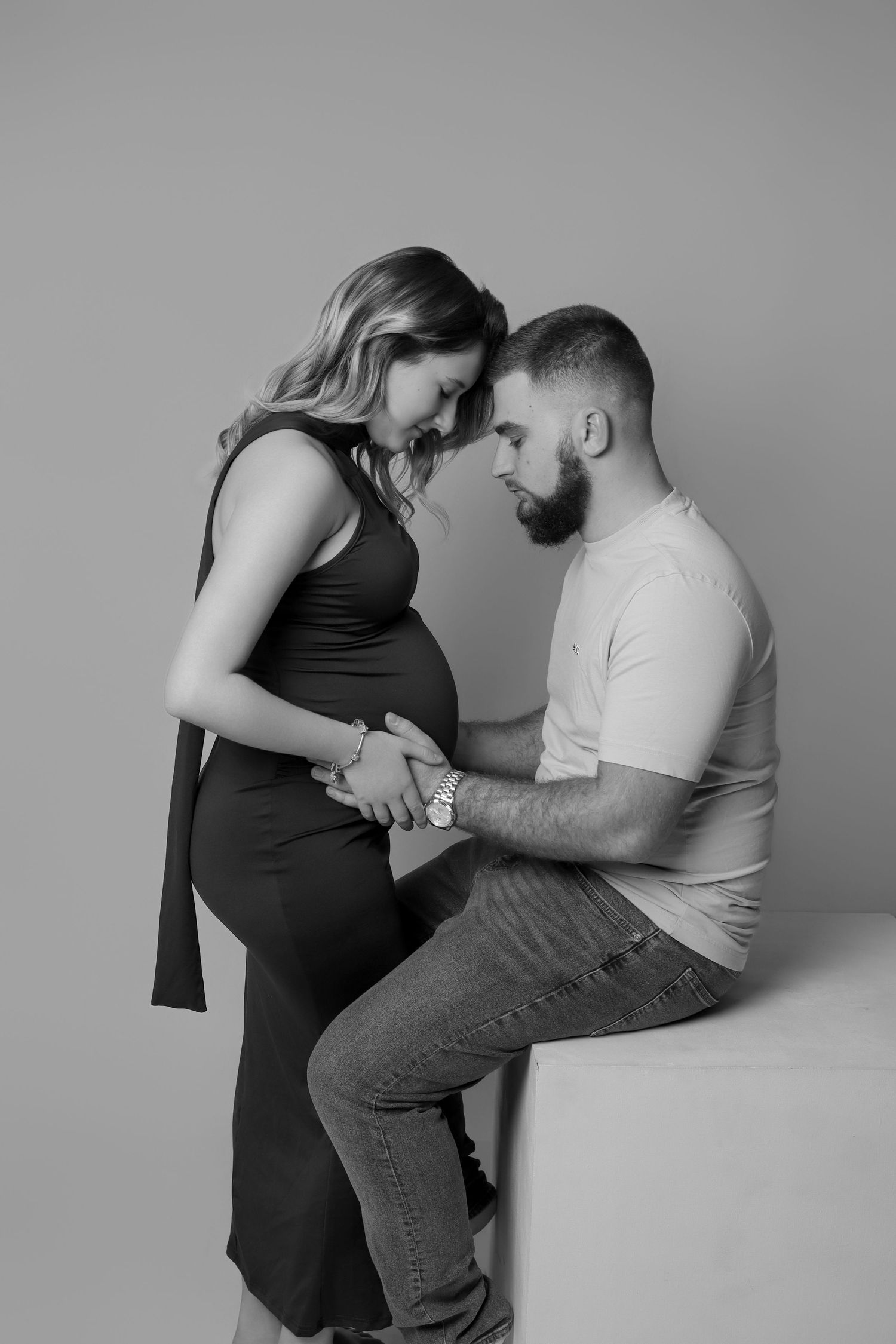 Portrait de couple en noir et blanc lors d'une séance photo de grossesse en studio par Cindy Poulet Photographe