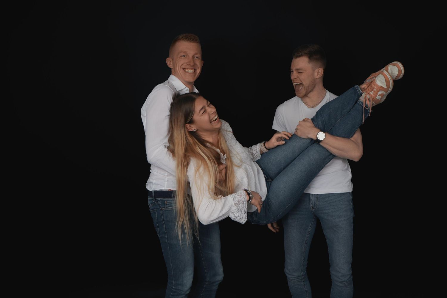 Trois personnes posant ensemble dans un studio en noir et blanc, séance famille