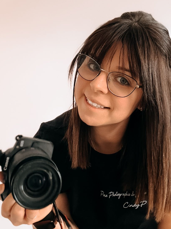 Portrait souriant de Cindy Poulet, photographe spécialiste du nouveau-né et de la famille. Elle pose en studio à Septvaux, près de Laon.