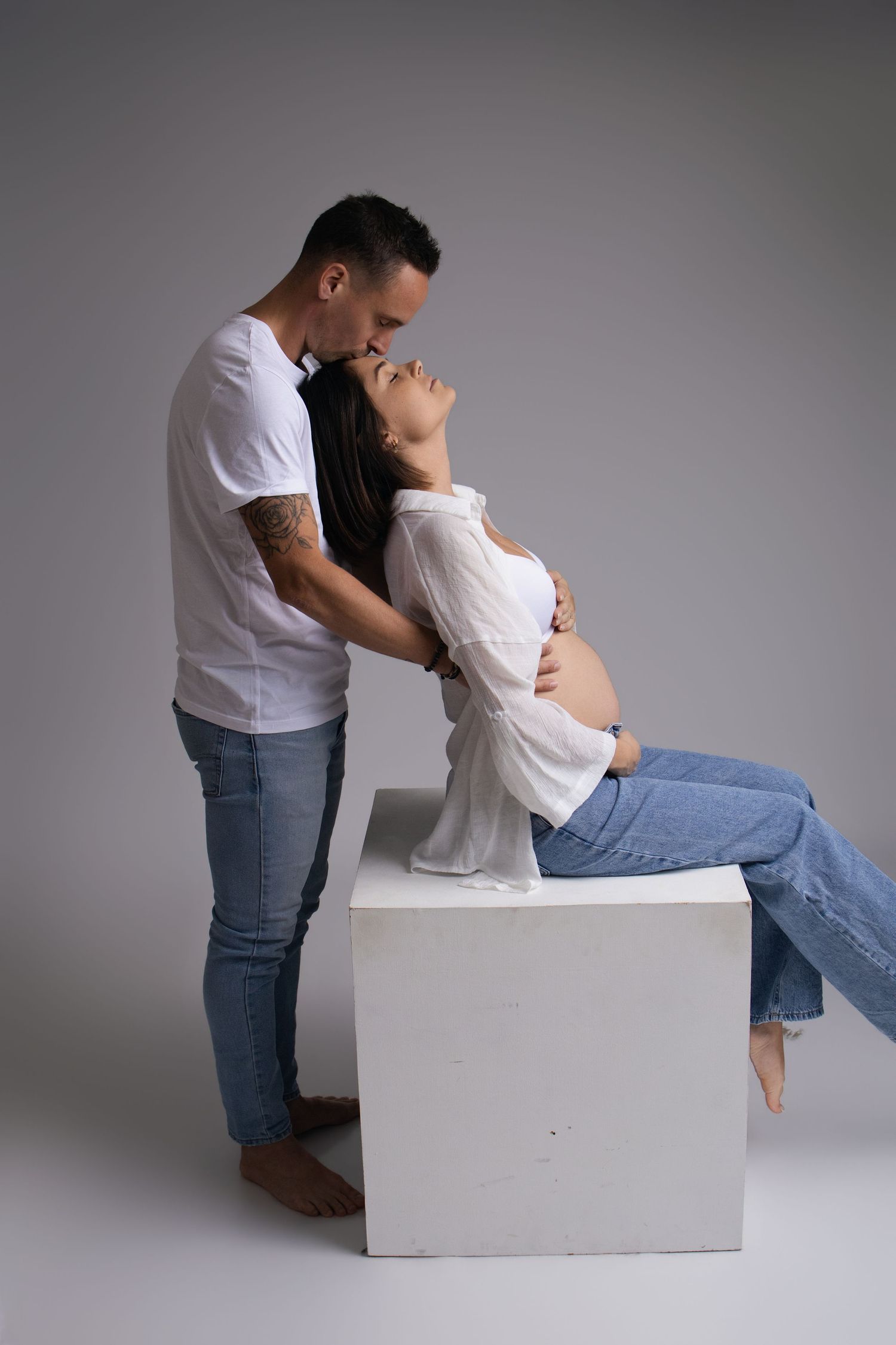 Photo de grossesse complice : futur papa regardant le ventre de la maman. Séance maternité par Cindy Poulet à Septvaux, près de Laon.