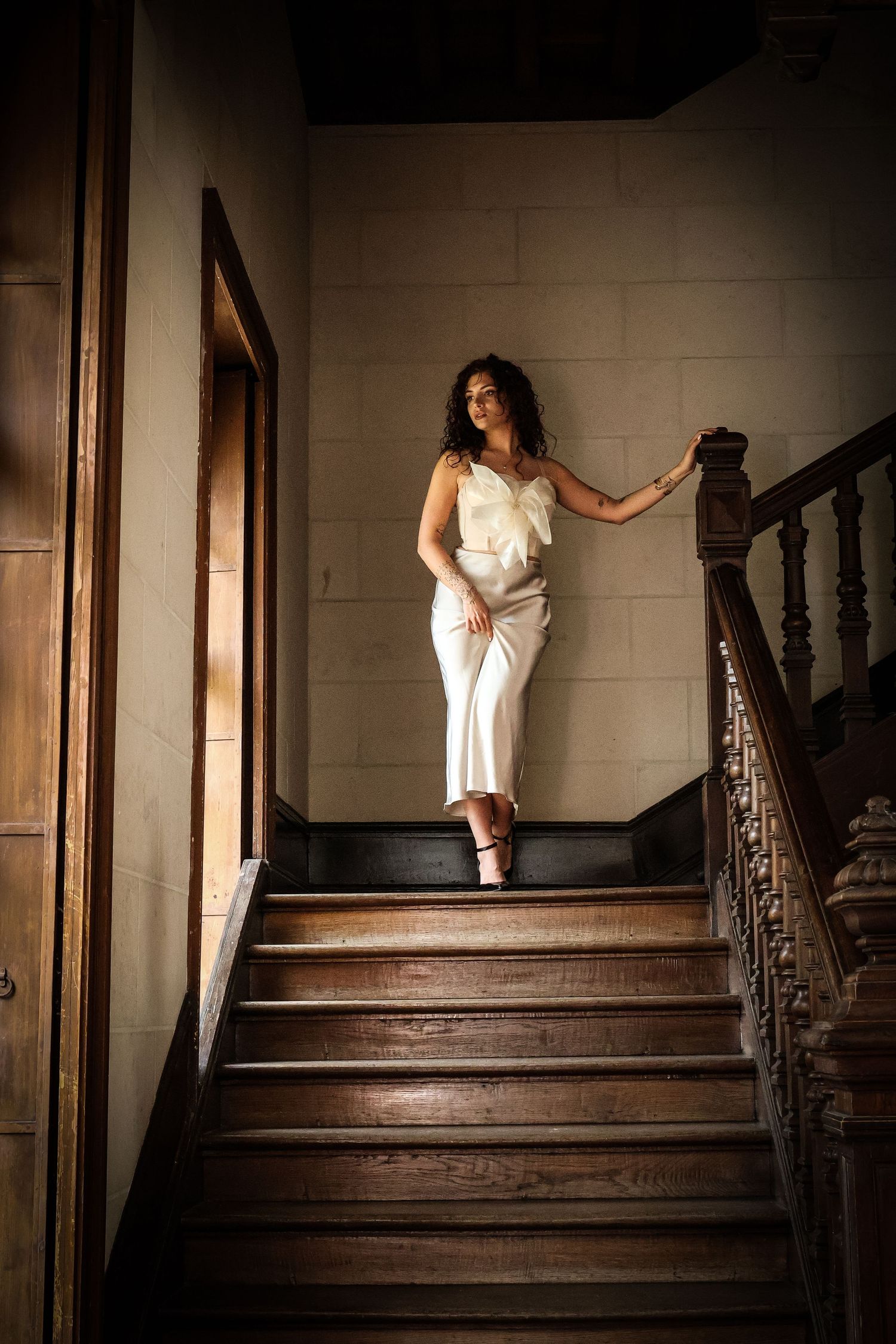 Femme élégante descendant un escalier en bois, portrait lifestyle