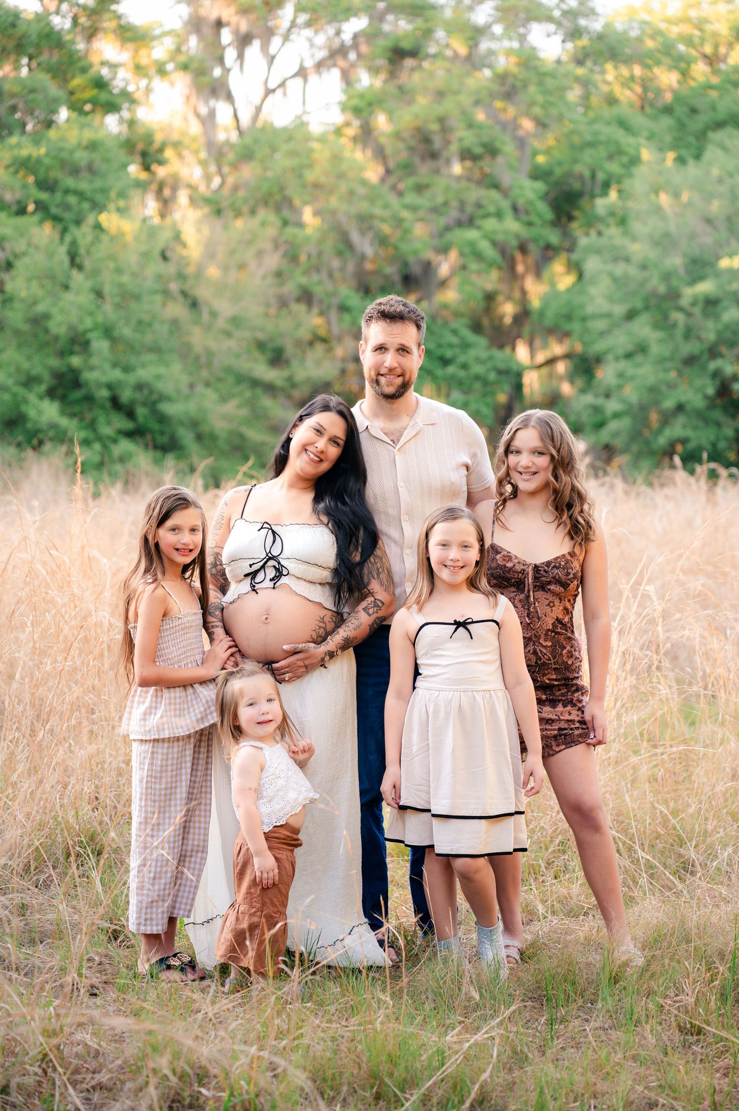 Outdoor family maternity portraits captured among the tall grass at Lake Runnymede Conservation Area in St. Cloud, Florida.
