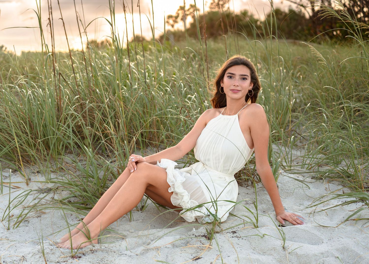 Beautiful senior graduation photography featuring the sandy shoreline, dunes, and golden sunset at Melbourne Beach.