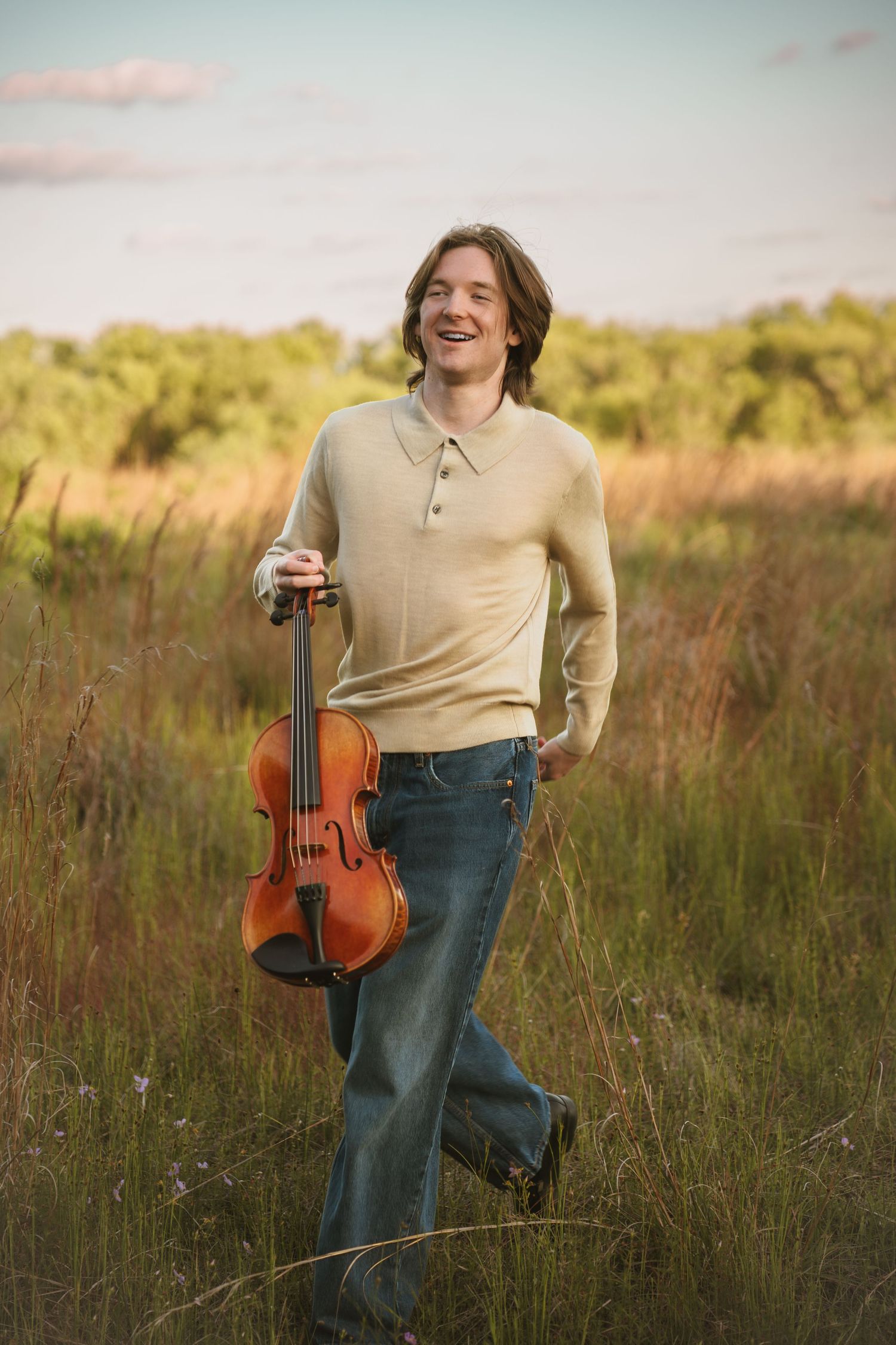 High school senior playing the violin during a graduation portrait session at Lake Runnymede Conservation Area in St. Cloud Florida