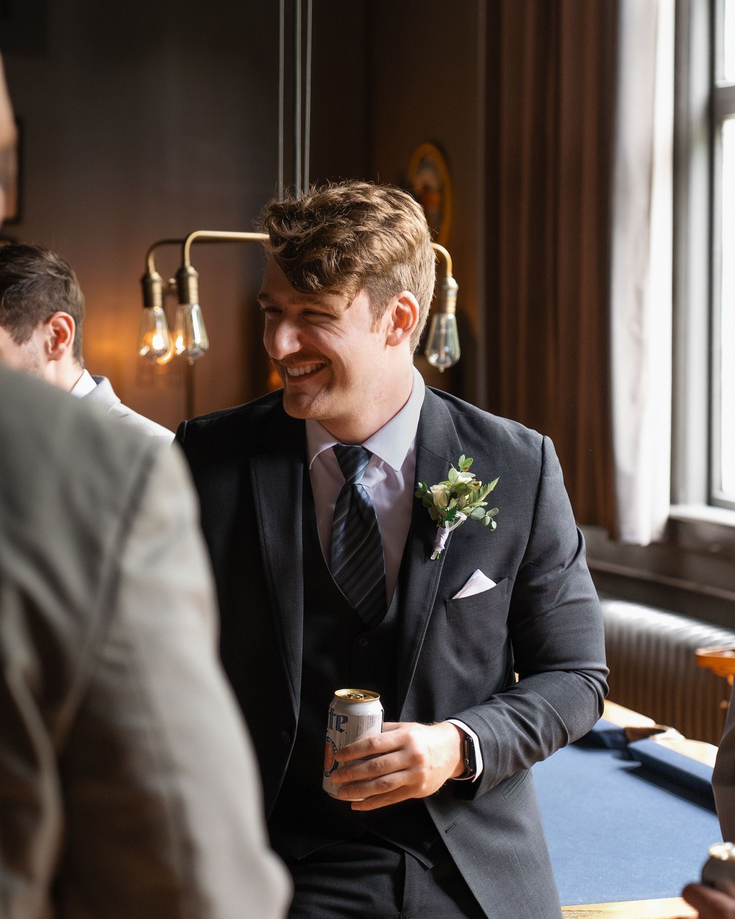 Candid moments of the groom and his groomsmen sharing laughs before the wedding at Historic Venue 1902.