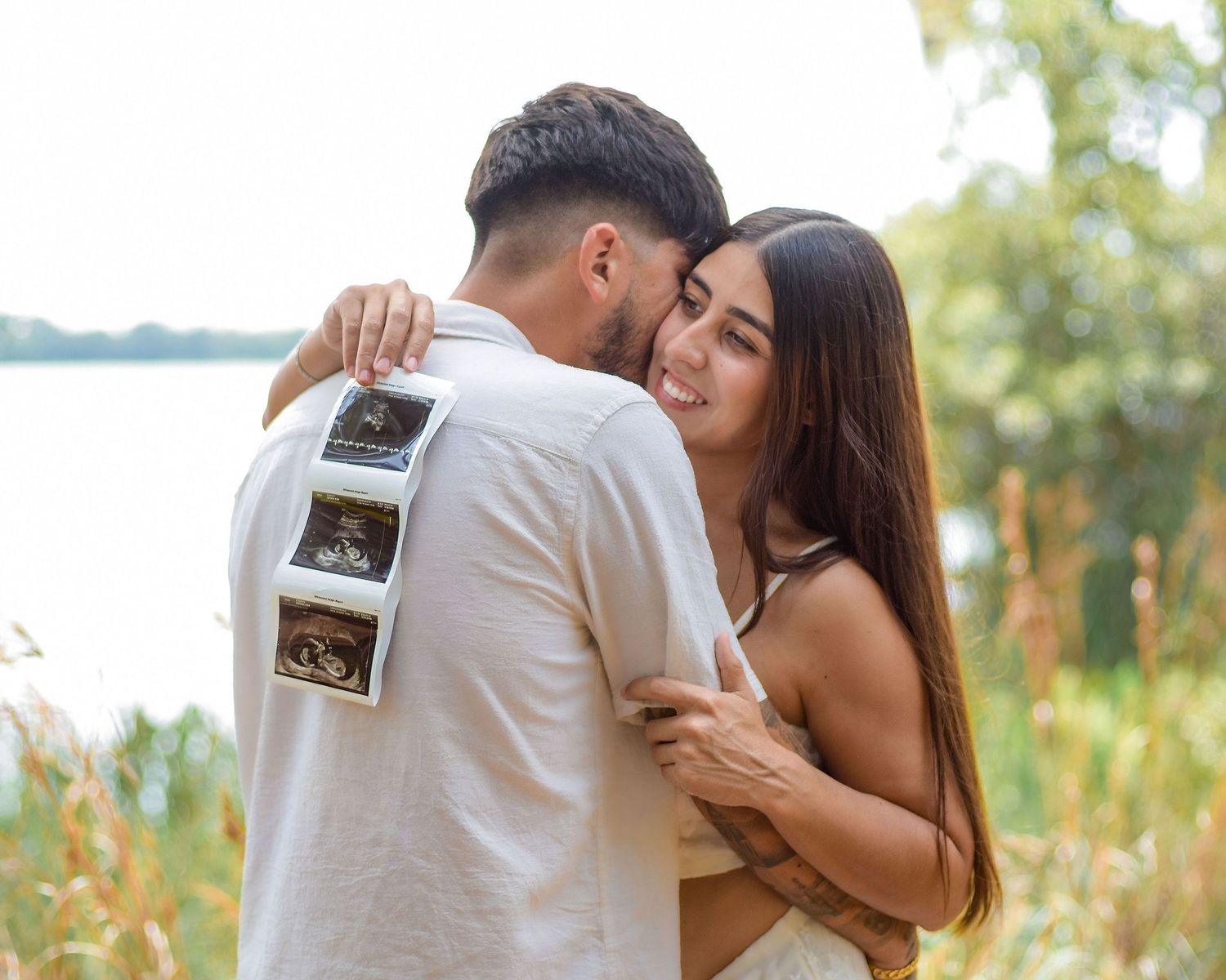 Couple holding ultrasound during outdoor maternity session with St Cloud Florida photographer Erin Laine Photo
