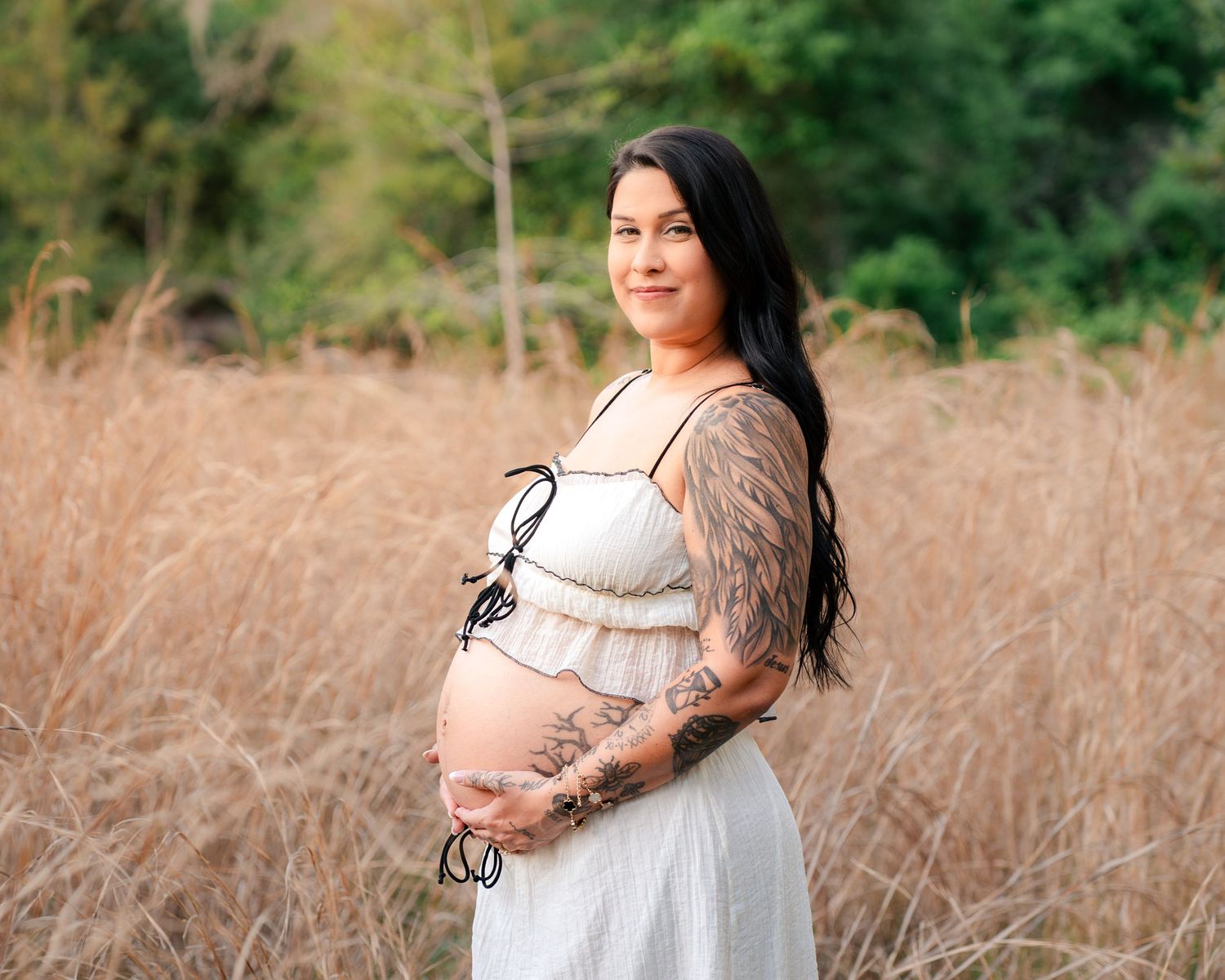 Beautiful maternity portrait of an expecting mother surrounded by tall grass at Lake Runnymede Conservation Area in St Cloud Florida