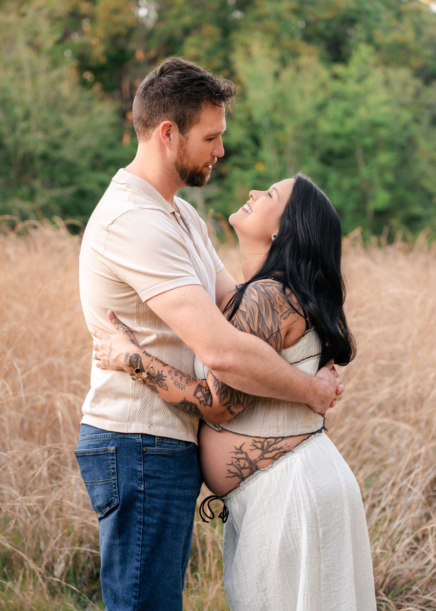 Expecting parents embracing during a golden hour maternity session at Lake Runnymede Conservation Area in St. Cloud, Florida.