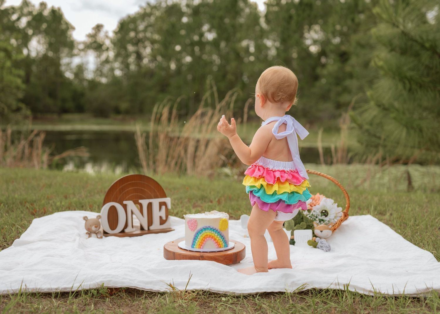 Outdoor cake smash photography documenting the fun and excitement of a first birthday celebration by St Cloud Florida family photographer